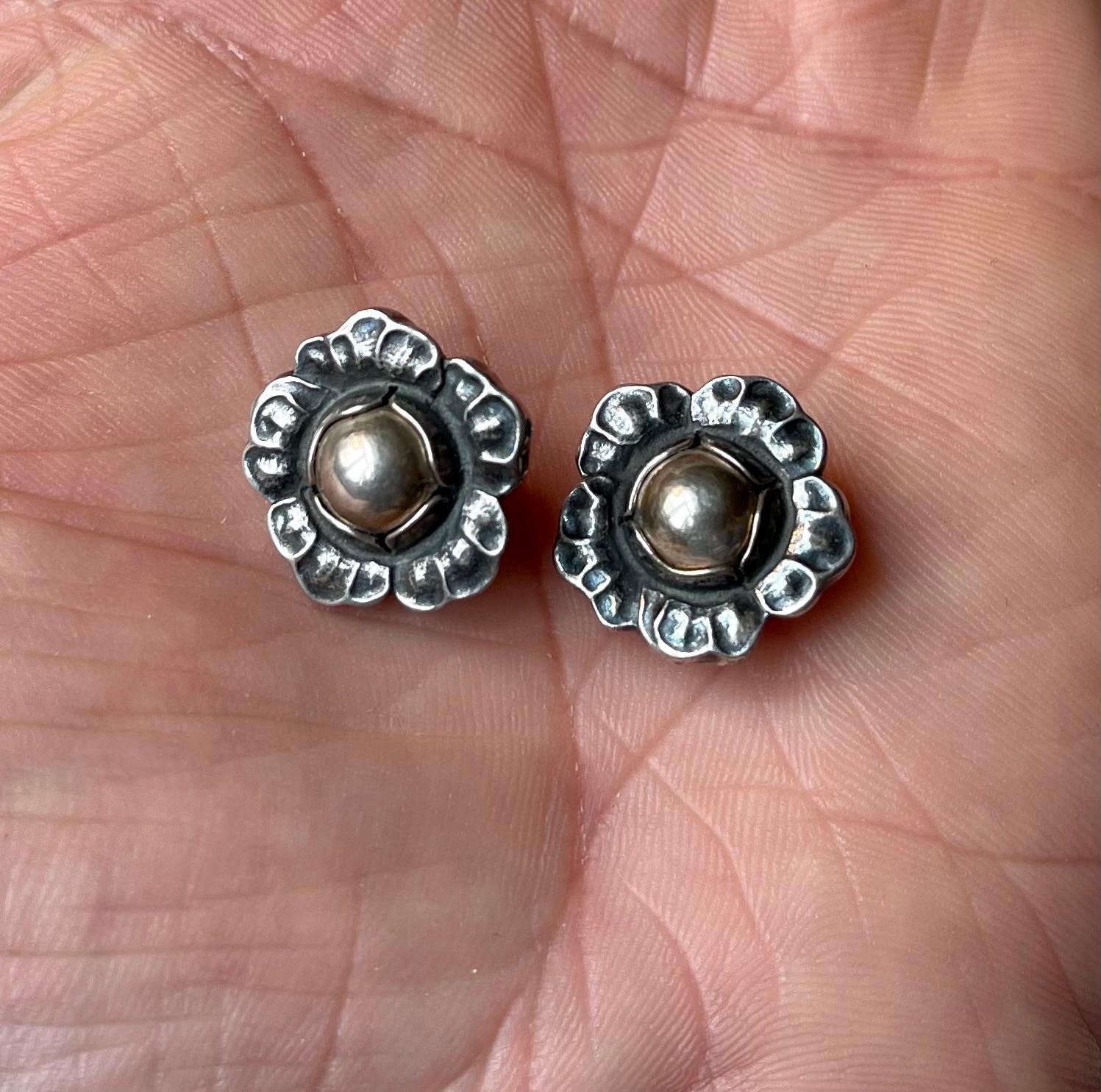 A set of 'Year' clip earrings by Georg Jensen. Based upon a design from circa 1900 these were relaunched in 2002. Floral design with silver-beads. Original box. Fully hallmarked. Measurements: 19x19x10 mm. Perfect vintage sustainable gift. The price