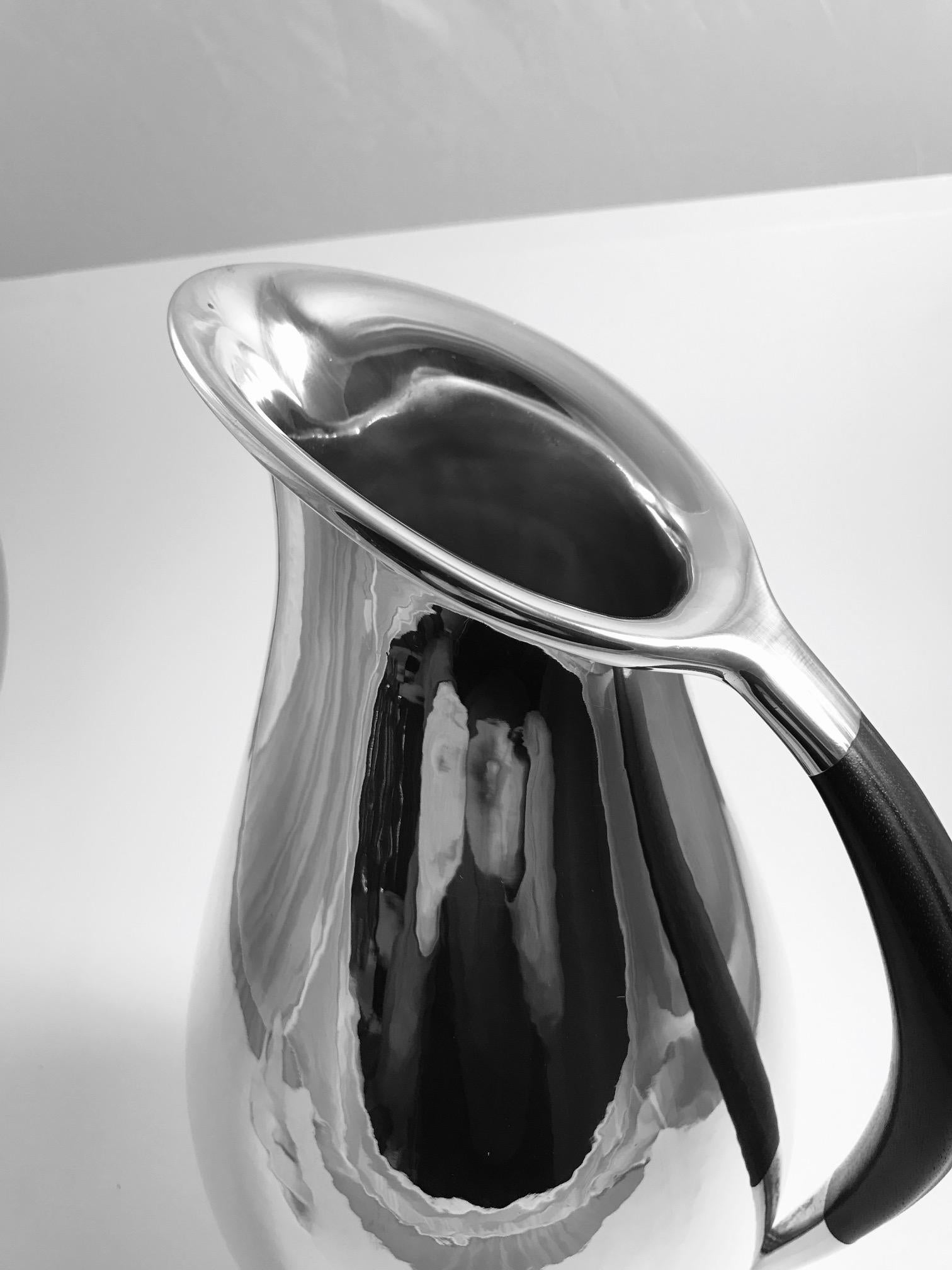 Ths is a Georg Jensen sterling silver pitcher with ebony handle, design #432E by Johan Rohde from 1920.
This design for Rohde was the topic of many conversations between him and Georg Jensen, as its minimalistic look in 1920 was before its time,