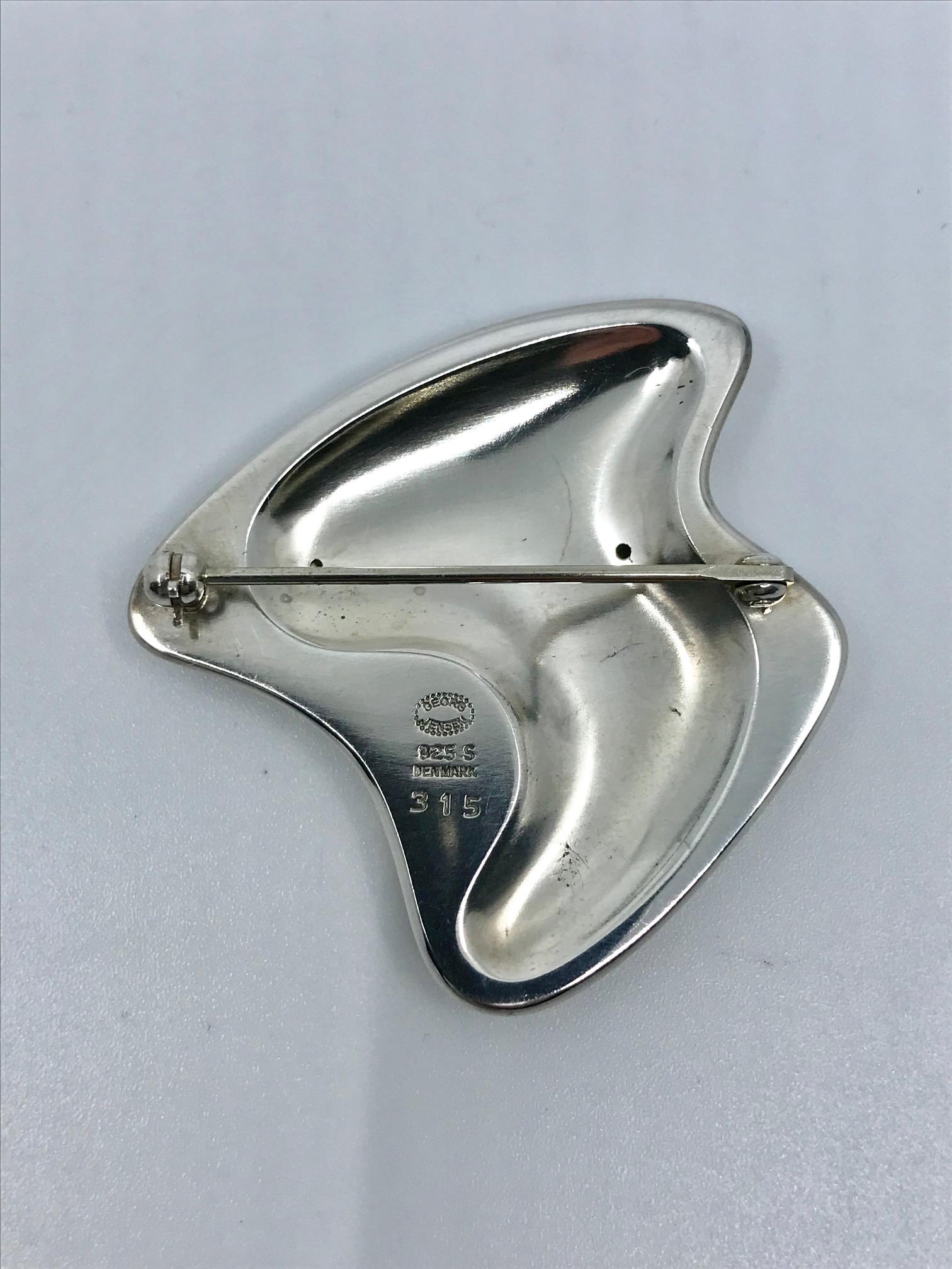 Modern sterling silver Georg Jensen brooch with black enamel, design #315 by Henning Koppel from circa 1954.
Measures 1 3/4″ x 1 3/4″ (4.3cm x 4.3cm).
Post 1944 Georg Jensen hallmark.
The enamel is undamaged.