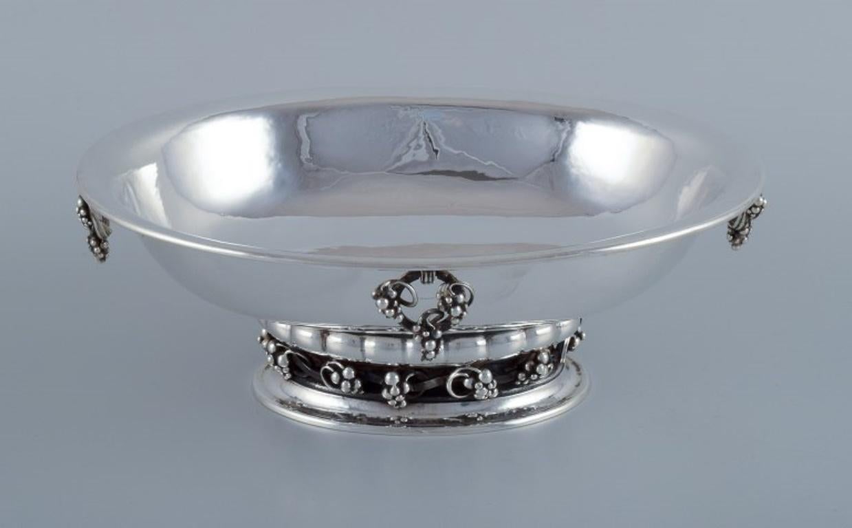 Georg Jensen, gran e impresionante centro de mesa en plata de ley. 
Con racimos de uva.
Aproximadamente desde 1920.
Model No.
Peso: 37 oz
Sellado.
Perfecto estado.
Dimensiones: Largo 27,4 cm x Ancho 21,4 cm x Alto 9,7 cm.