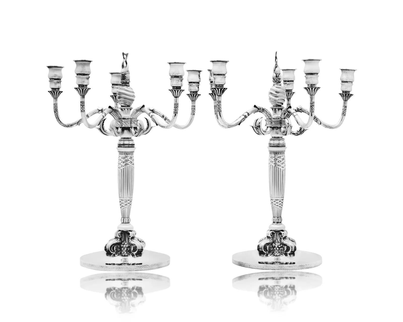 Pareja de candelabros de plata de ley Georg Jensen de cinco luces, diseño nº 224 de Johan Rohde, introducidos originalmente en 1916. Cada candelabro presenta cinco elegantes ramas que emergen de hojas estilizadas, con un llamativo remate de dos