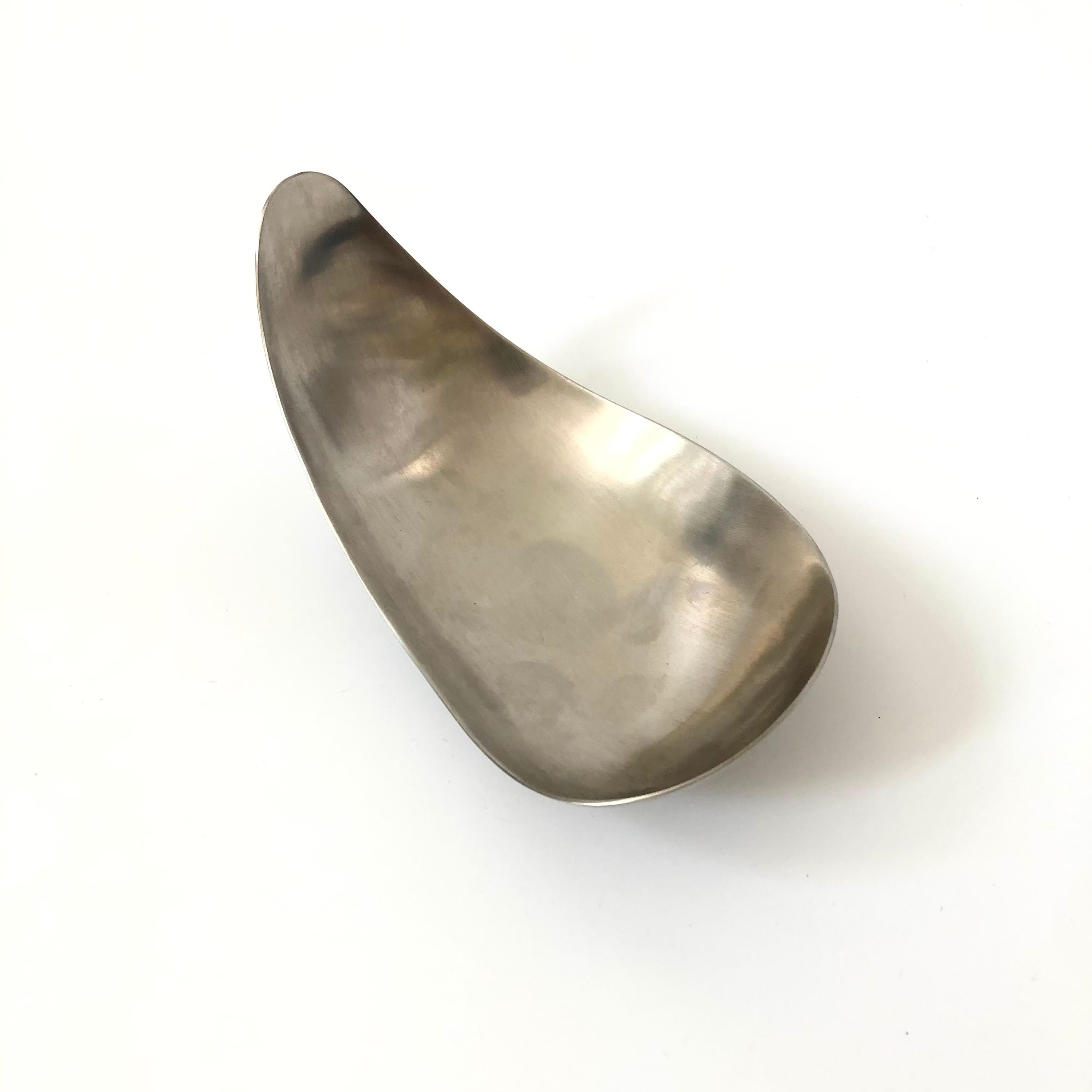 A mid century metal bowl designed by Helle Damkjær for Georg Jensen. Dramatic curved shape. Made of brushed stainless steel. Marked on the base.

