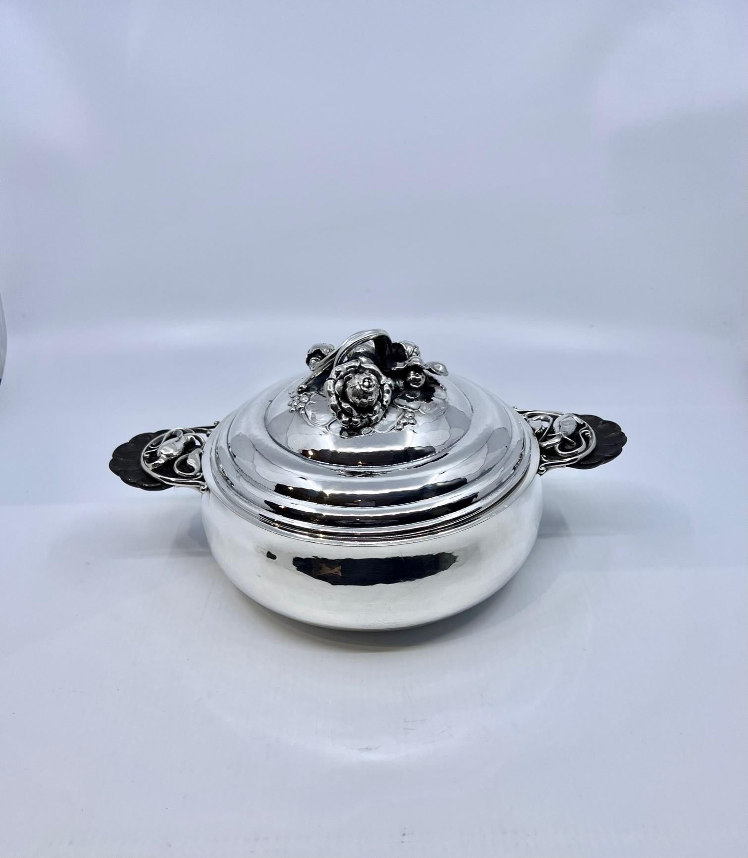 An ornate art nouveau Danish sterling silver Georg Jensen lidded tureen with shell carved ebony handles, design #417A by Georg Jensen from circa 1920. This design is referred to as 