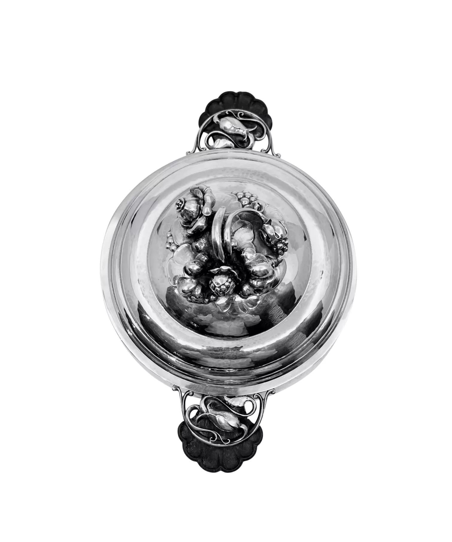 An ornate art nouveau Danish sterling silver Georg Jensen lidded tureen with shell carved ebony handles, design #417A by Georg Jensen from circa 1920. This design is referred to as 