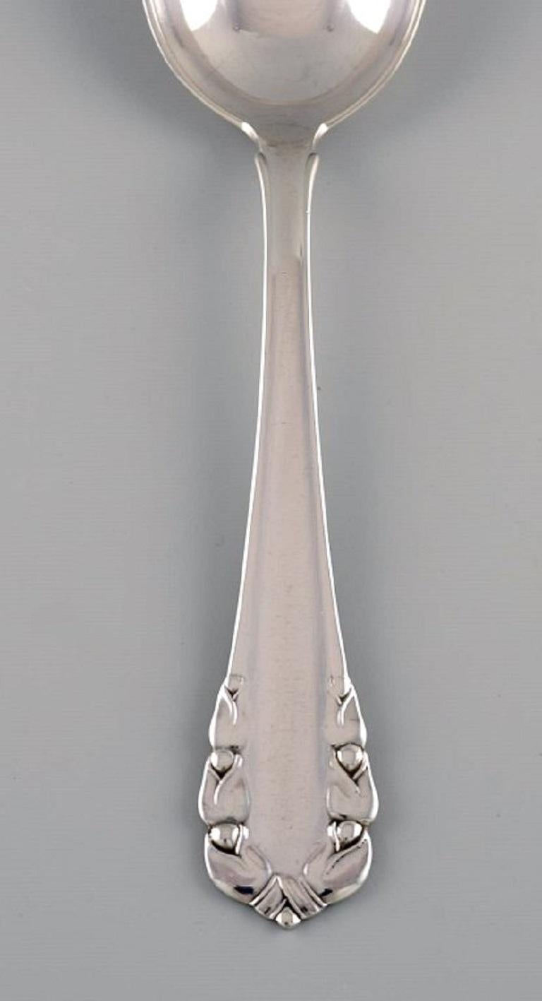 Georg Jensen Lily of the Valley dessert spoon in sterling silver. Dated 1933-1944. 
Six spoons are available.
Measure: Length: 17.3 cm.
In excellent condition.
Stamped.
Our skilled Georg Jensen silversmith / goldsmith can polish all silver and