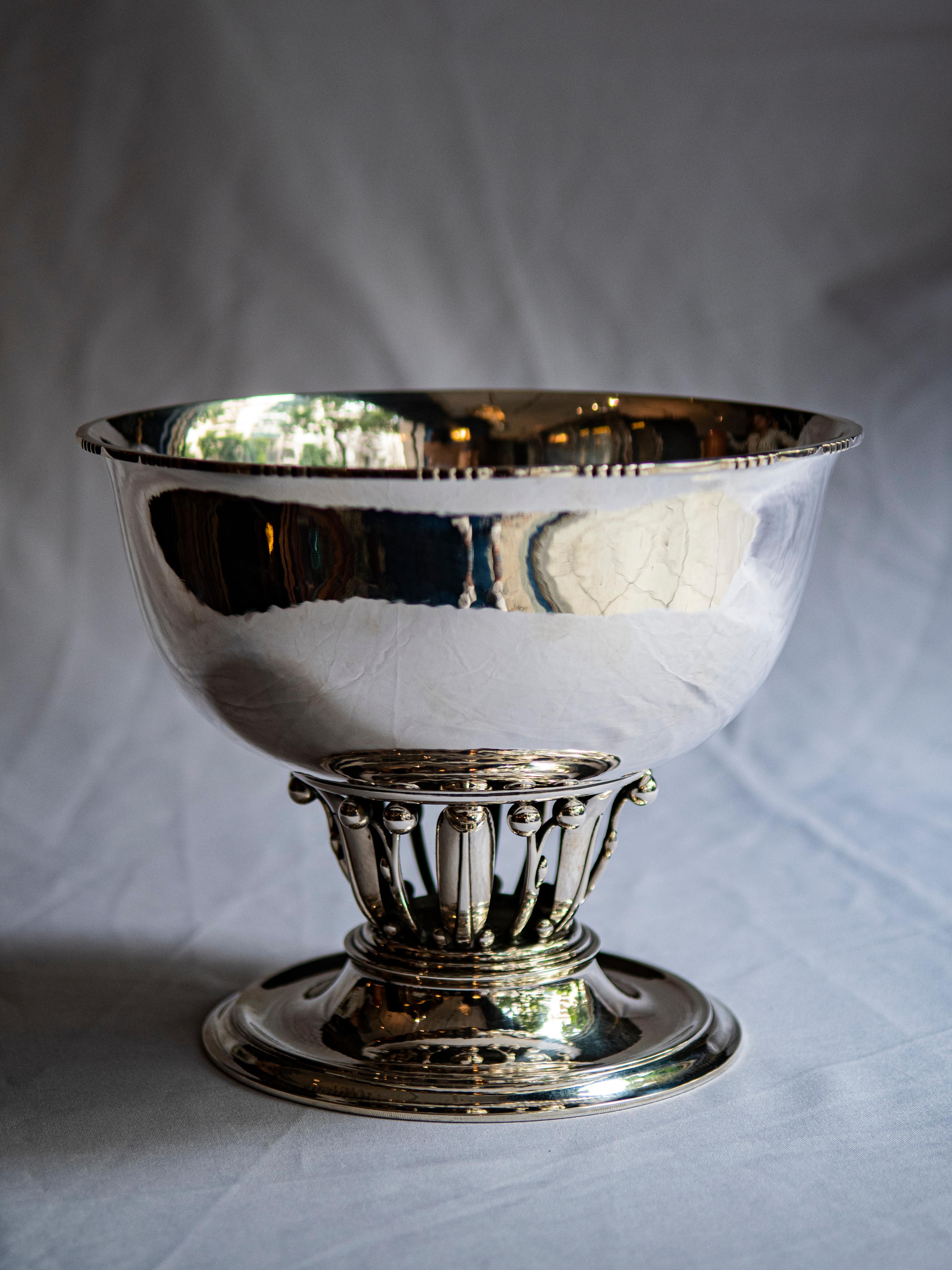 
Indulge in the timeless elegance of Danish craftsmanship with this exquisite center footed bowl, bearing the mark of the esteemed Georg Jensen. Dating back to the years 1933-1944, this masterpiece is a testament to Jensen's enduring legacy as one