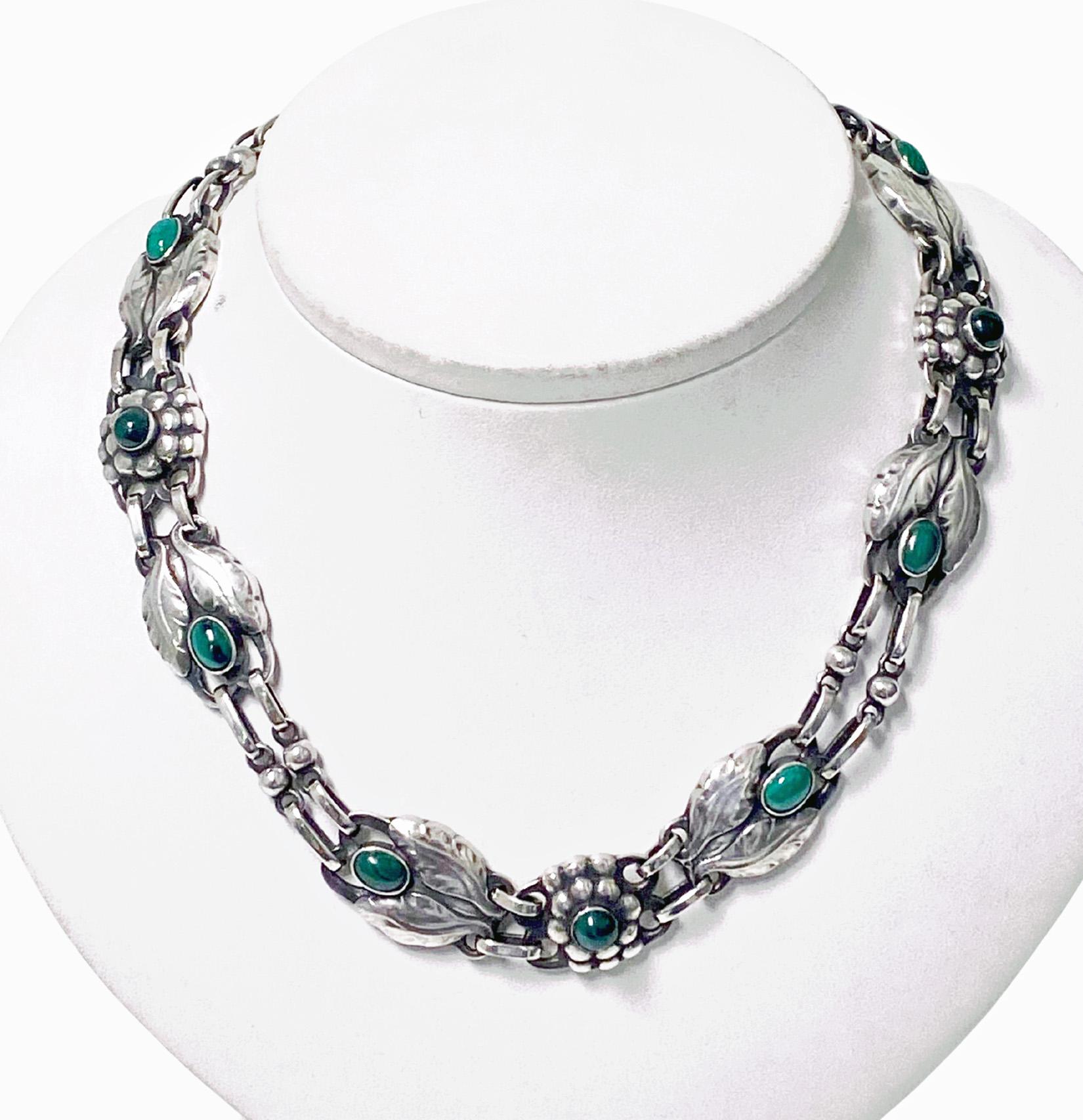 Georg Jensen Malachite and Sterling Silver Necklace No 1. Bezel set oval and round malachite with stylised bud leaves and berries interval links. Full Jensen marks to reverse. Length 14.75 inches. Item Weight: 55 grams. Reference similar example P