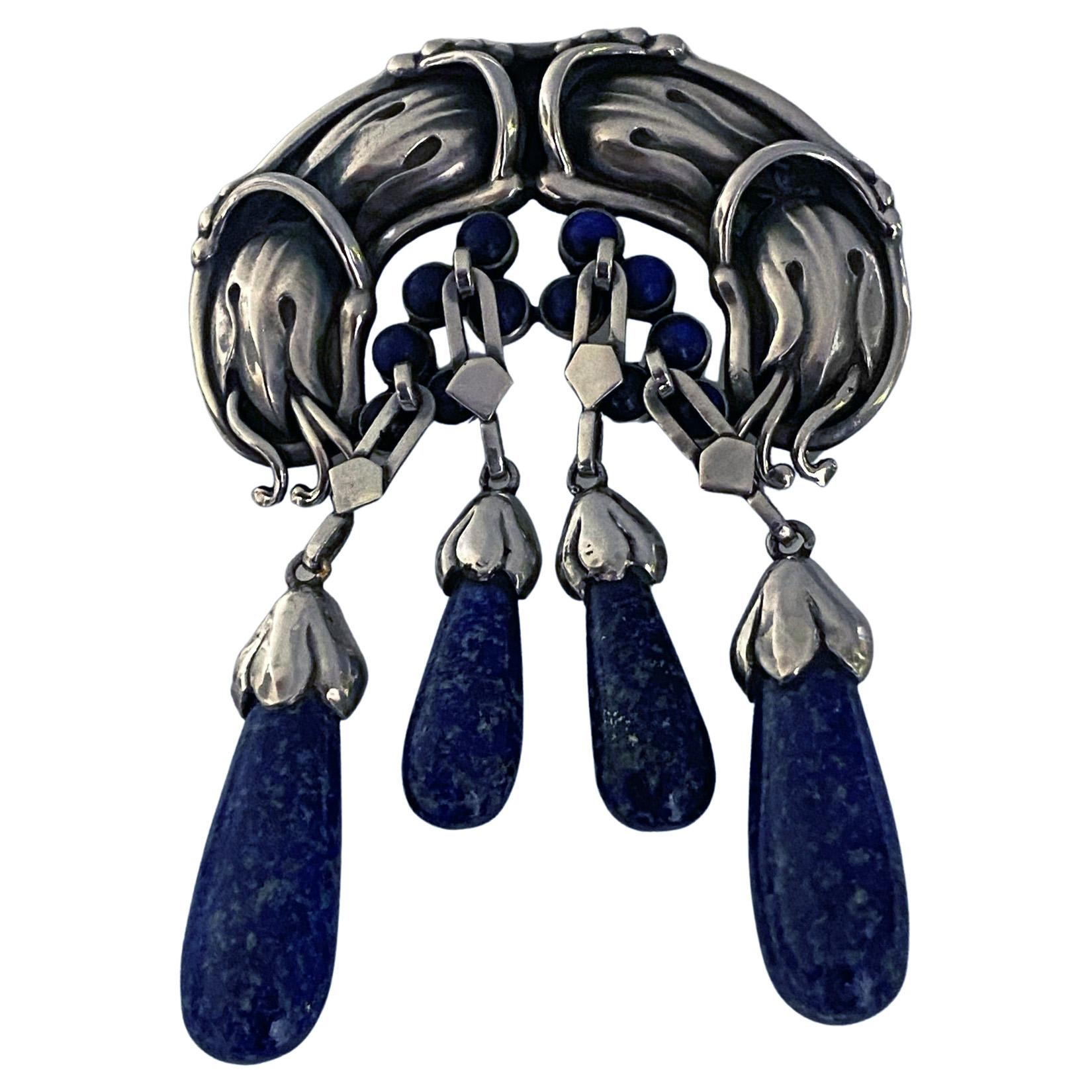Important Georg Jensen Large rare Silver Lapis Lazuli Master Brooch, C.1930. Georg Jensen. Designed as elaborate foliate and bud motifs set with and suspending lapis lazuli cabochons and drops, no. 22, 9.10 cm, width 7 cm. Item Weight: 64 grams.