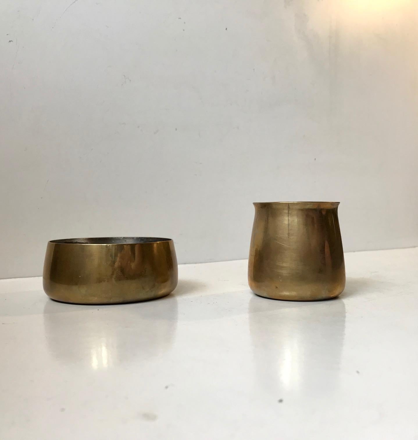 A rare set consisting of a small creamer and sugar bowl in solid brass lined with pewter. Designed by Henning Koppel and manufactured by Georg Jensen in Denmark for a brief time during the 1960s. Measurements: D: 8.6/6 cm, Heights: 6.5/4 cm. The set