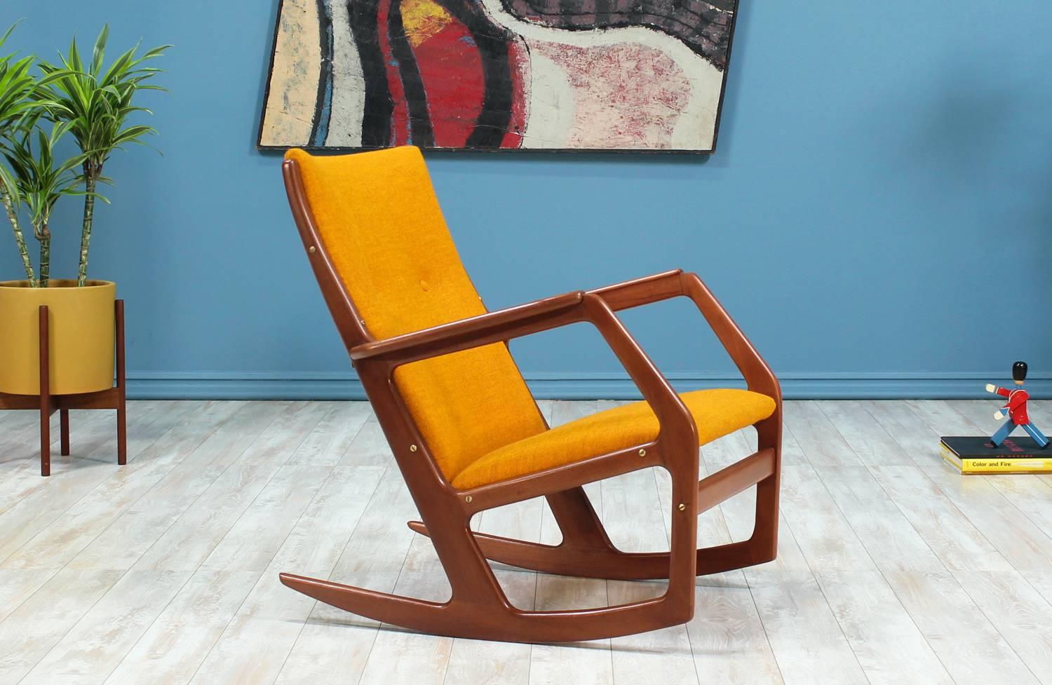 Rocking Chair designed by Georg Jensen for Kubus Møbler in Denmark circa 1960’s. The Model-100 features a teak wood frame with sculpted arms and supported by a front stretcher, with the back and seat upholstered in a vibrant mustard yellow tweed