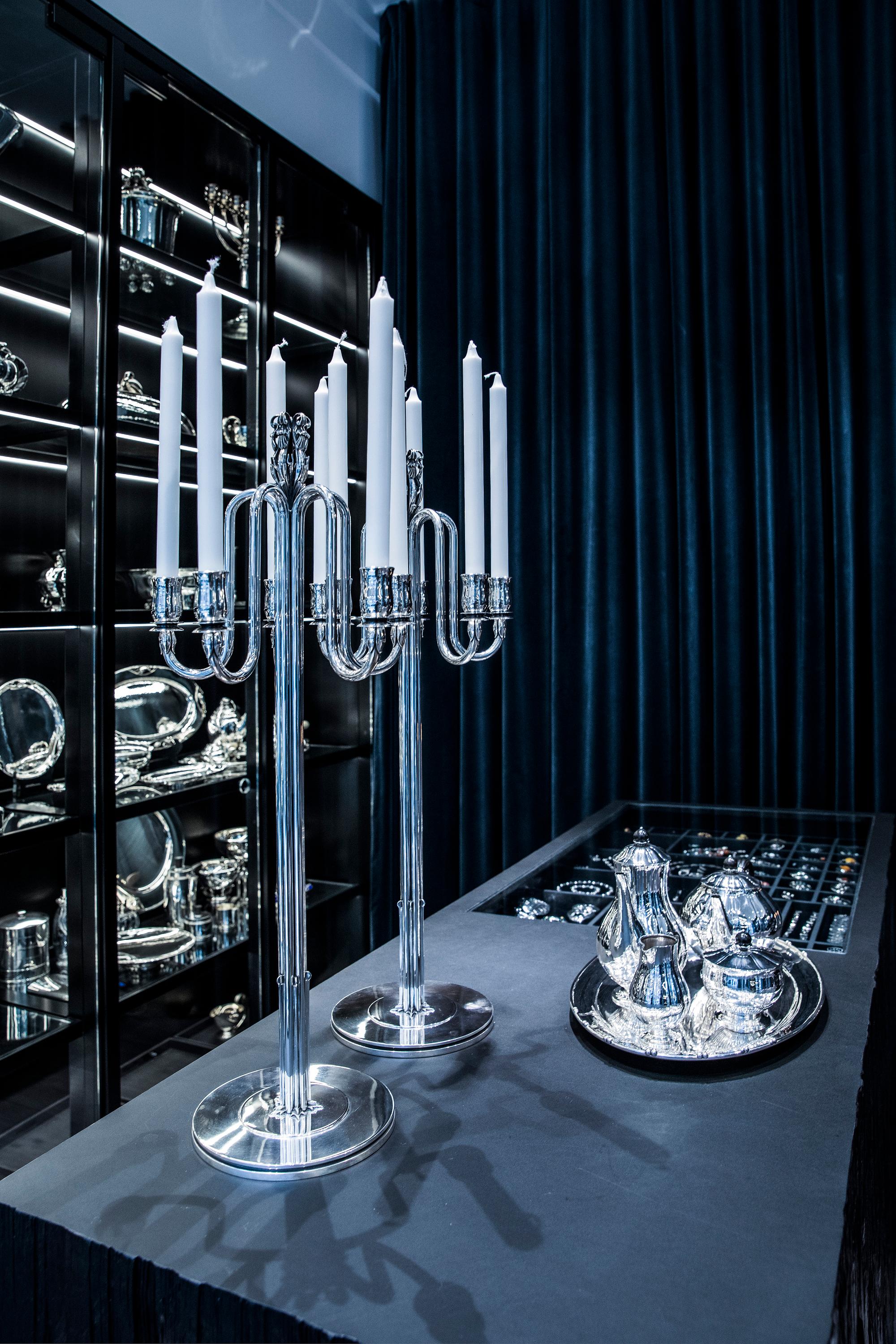 A striking pair of monumental Georg Jensen Art Deco sterling silver candelabra, designed by Harald Nielsen in 1938. These exemplars stand as perhaps the tallest creations within the Jensen lineage, soaring to an impressive 30 1/4 inches (77cm) in