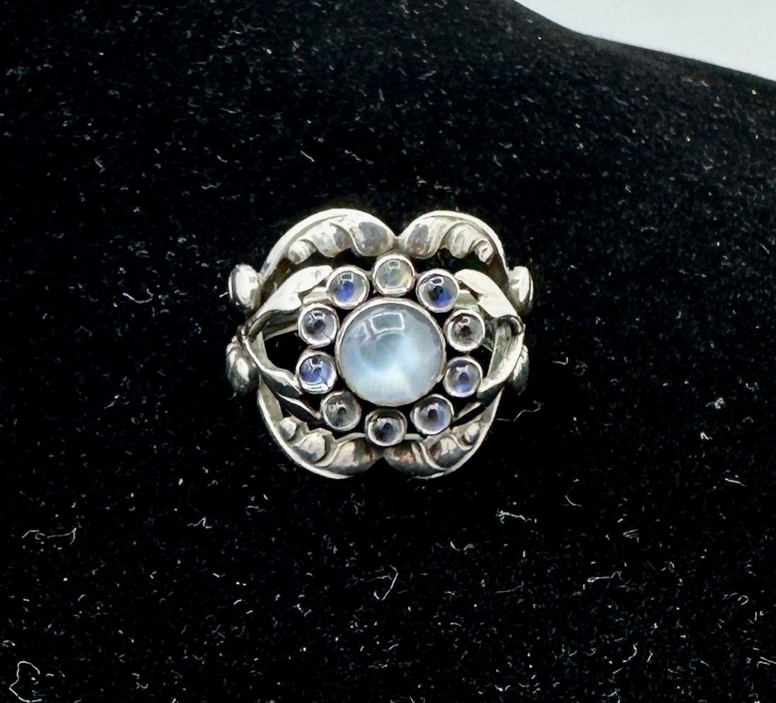 This is the classic Georg Jensen Moonlight Blossom Moonstone Sterling Silver Ring Number 10.  The ring is in absolutely gorgeous condition and comes from a superb collection of Georg Jensen jewelry.  The early Georg Jensen Moonlight Blossom