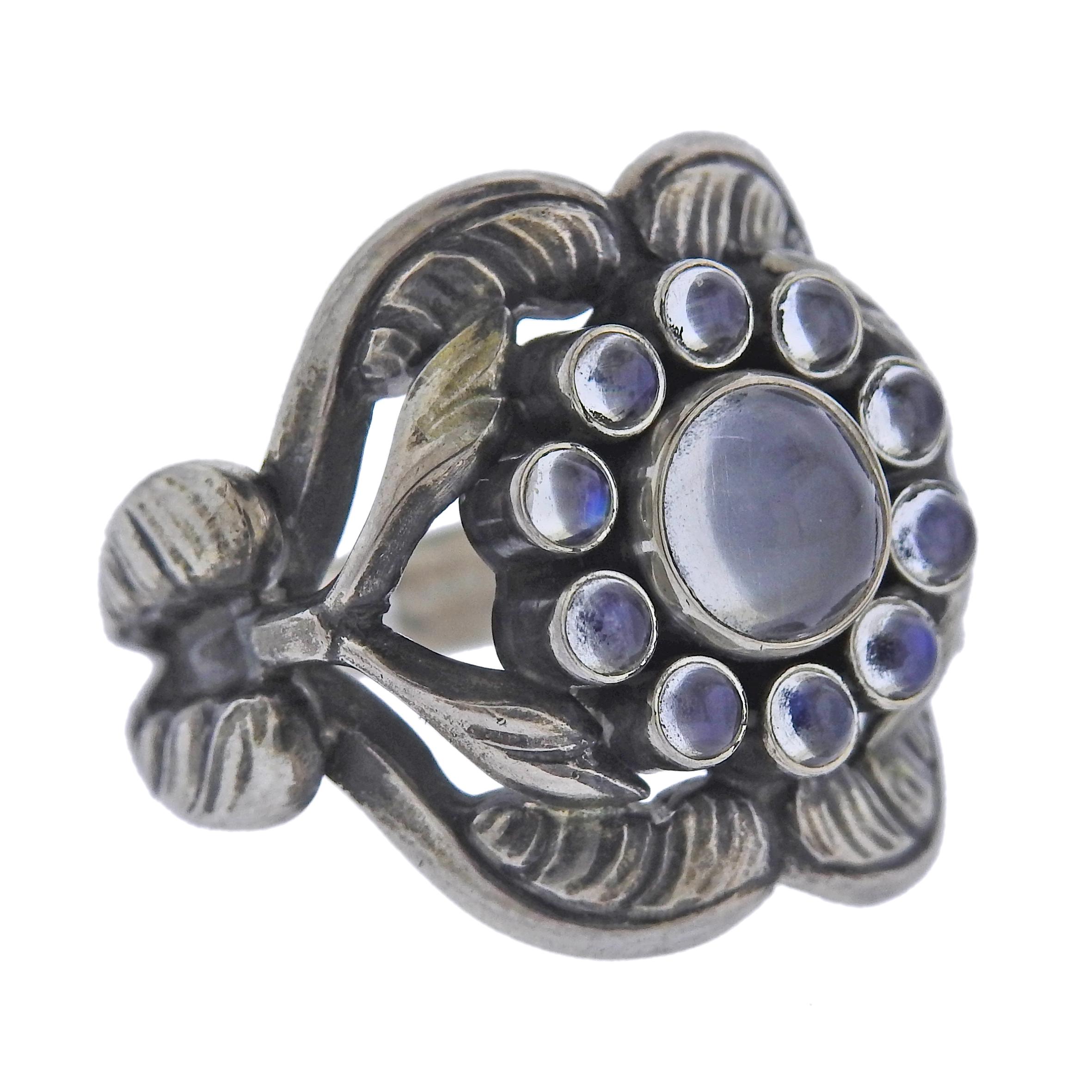 Brand new Georg Jensen sterling silver ring from Moonlight blossom collection, with moonstones.  Ring top is 21mm wide. Available in sizes : 54; 55. Model #3550260. Marked: GJ mark, 925 S, 10 Weight - 9.1 grams.