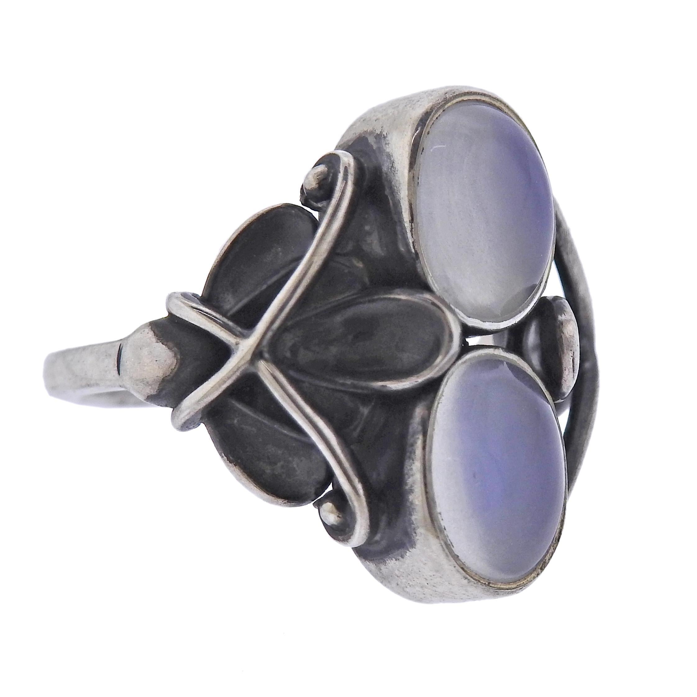 Brand new Georg Jensen sterling silver ring from Moonlight blossom collection, with moonstones. Ring top is 21mm wide. Available in sizes : 54, 53. Model # 3550620. Marked: GJ mark, 925 S, 48. Weight - 6.7 grams.