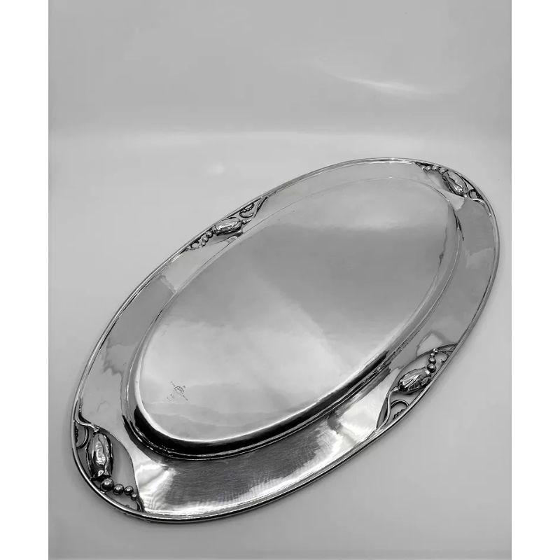 A sterling silver Georg Jensen  Blossom/Magnolia Tray, design #2AA by Georg Jensen. The Blossom pattern goes back to 1905 when Georg Jensen designed the Blossom teapot, his first hollowware design. Many pieces have since been made to supplement the