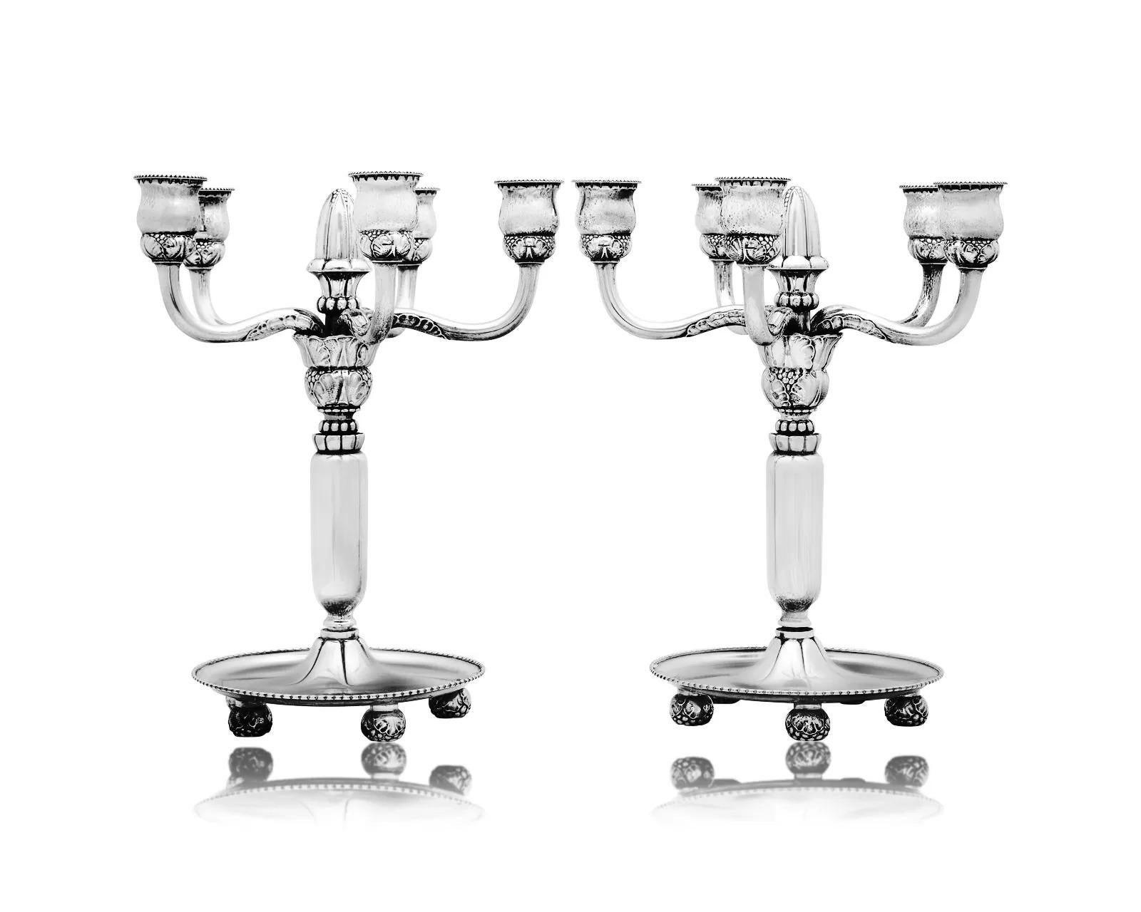 Pareja de primeros candelabros monumentales Art Nouveau Georg Jensen de plata de ley, diseño n.º 200 de Georg Jensen, hacia 1918. Cada candelabro descansa sobre una gran base circular abovedada con borde de cuentas, sostenida por cuatro pies en