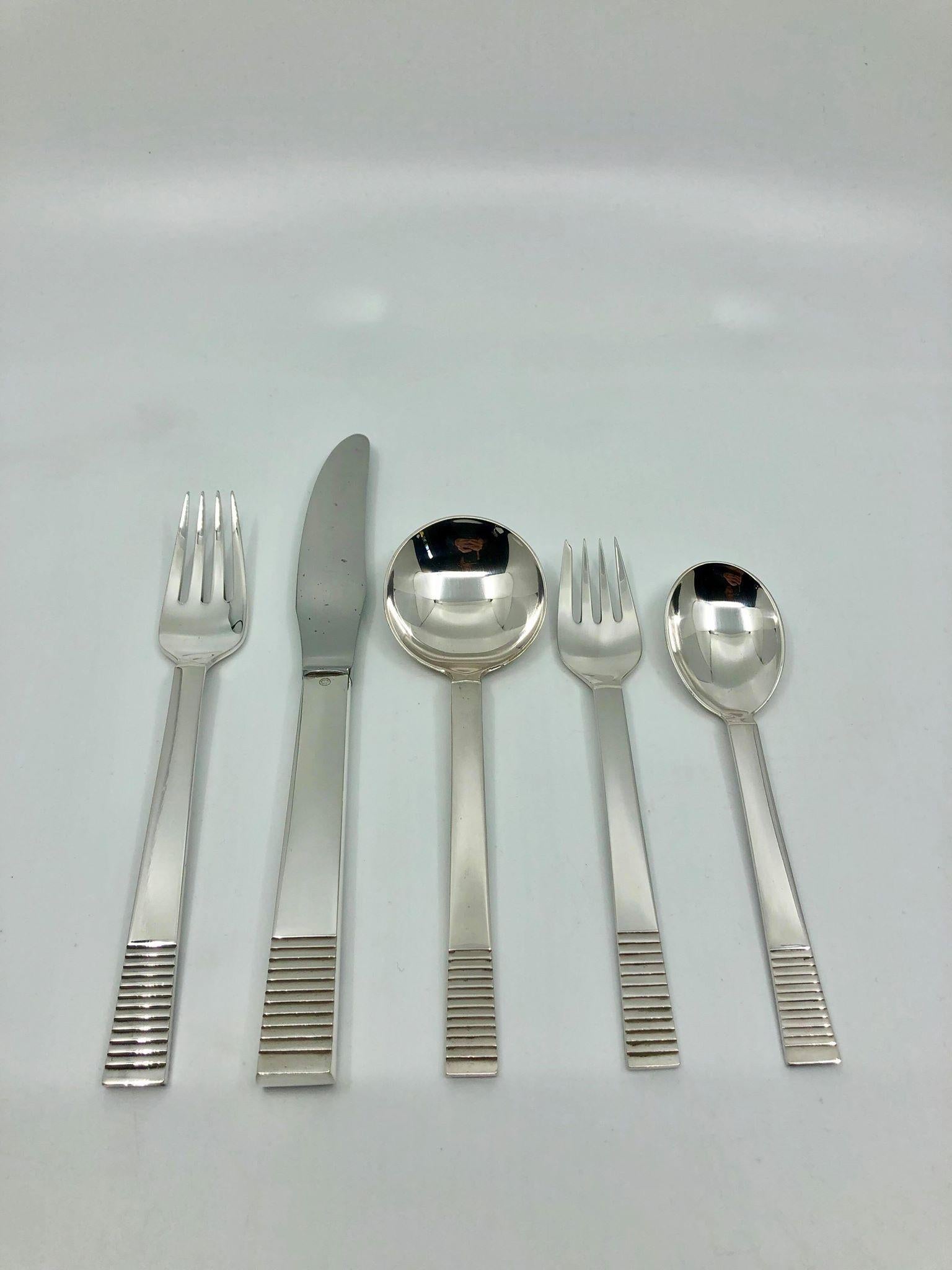 This is a sterling silver Georg Jensen Art Deco silverware service for twelve people in the parallel pattern, design #25 by Oscar Gundlach-Pedersen from 1931.

This set includes:

12 x dinner fork 7