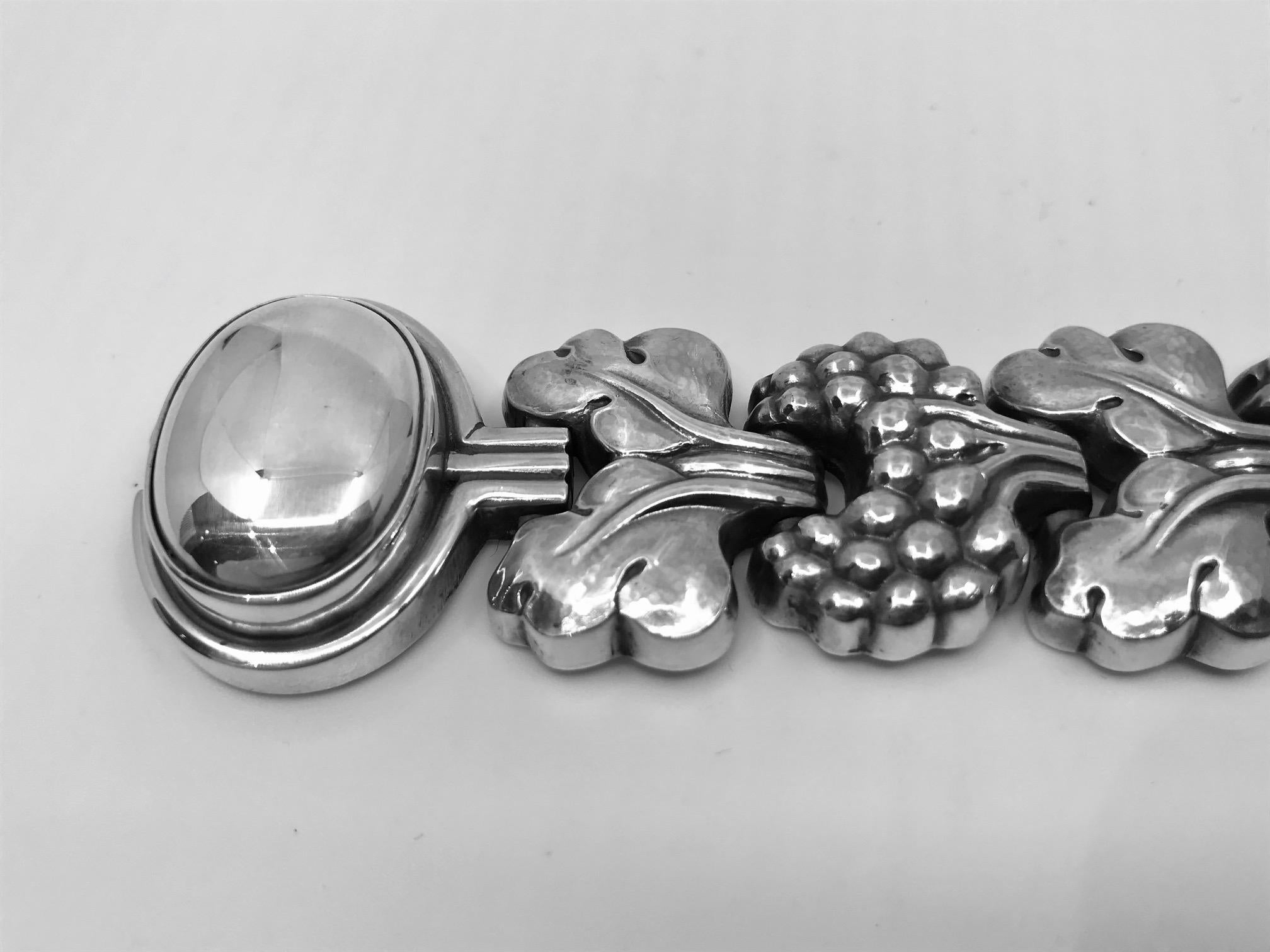 Sterling silver Georg Jensen bracelet with stylized berries and leaves and a large oval cabochon set silver bead on the lock, design #30 by Georg Jensen. This piece was designed during a brief period when Georg Jensen moved to Paris,