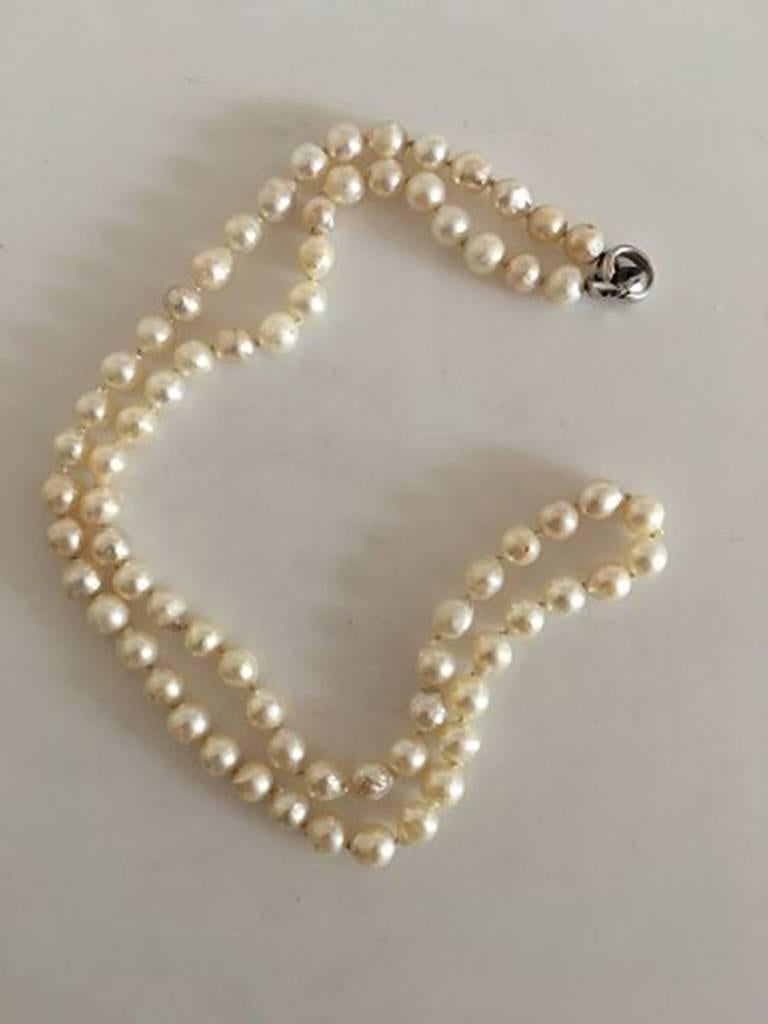 Georg Jensen Pearl Necklace with Lock and White Gold. The chain measures 63 cm L (24 51/64 in). The pearls measures 0.6 mm. Weighs 49 grams (1.75 oz). In good condition.