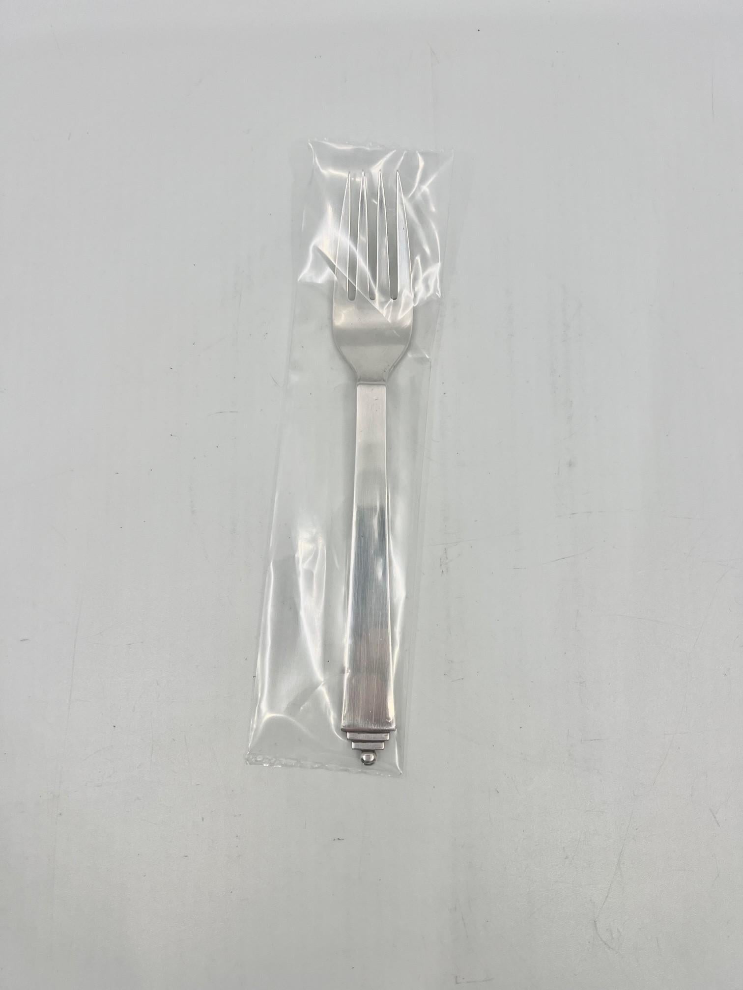 A sterling silver Georg Jensen luncheon/salad fork, item 022 on the Pyramid pattern, design #15 by Harald Nielsen from 1926.

Additional information:
Material: Sterling silver
Styles: Art Deco
Hallmarks: Georg Jensen hallmarks from