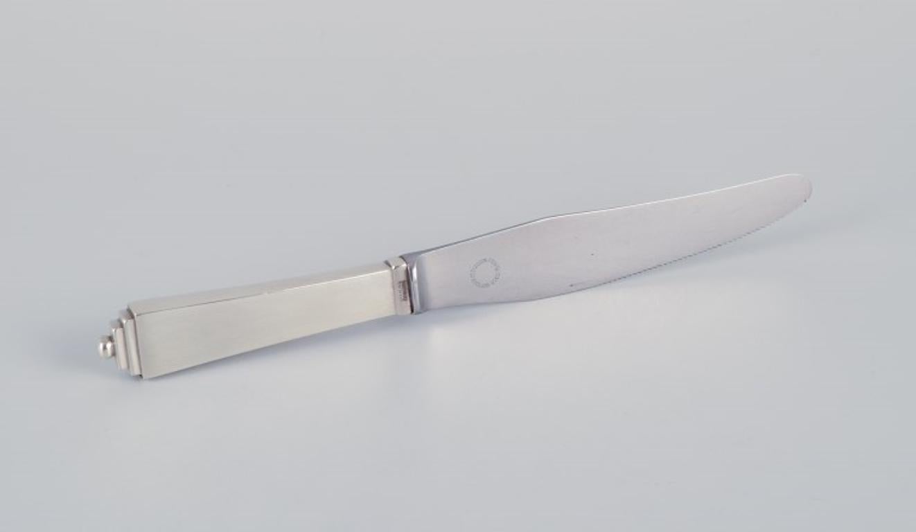 Georg Jensen Pyramide. 
Art Deco lunch knife with a long handle, stainless steel blade, and serrated edge.
1933-1944 hallmark.
In excellent condition.
Dimensions: Length 19.7 cm.