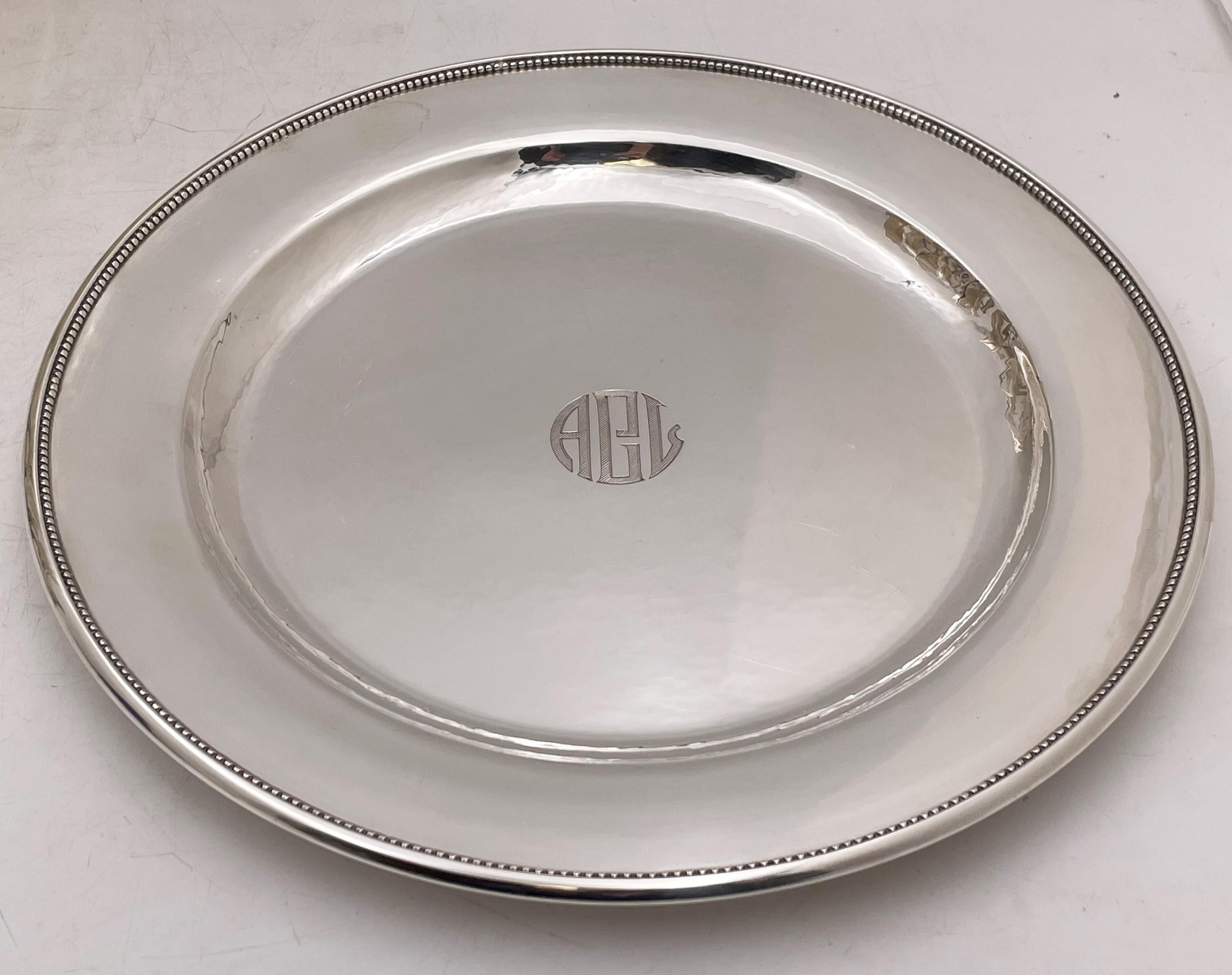 Georg Jensen set of 12 sterling silver chargers/dinner plates (diameter 11in) with a hand-hammered surface and a beaded rim pattern along the edge, bearing hallmarks and monograms as shown. Total weight is 254 ozt.

Danish silversmith George Jensen