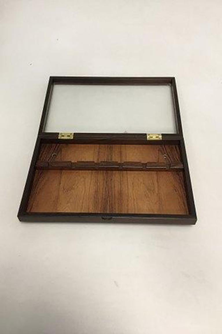 Scatola da parete in legno di palissandro di Georg Jensen per cucchiai. Realizzato in palissandro brasiliano. Coperchio con vetro montato. Tappato e montato con cerniere e viti in ottone. 

Misure: L: 31,9 cm (12 9/19