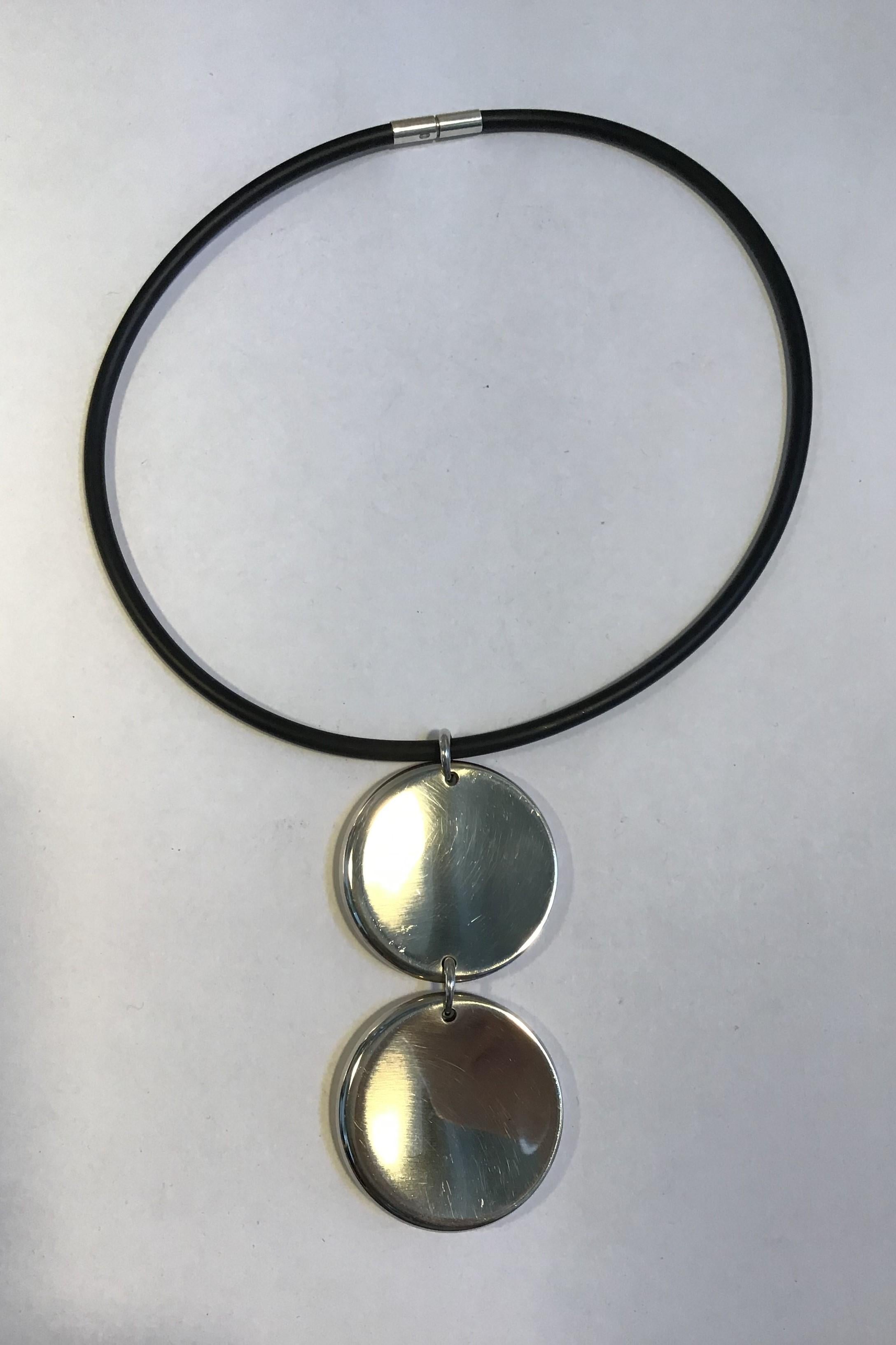 Georg Jensen Rubber Neck Ring and Sterling Silver Pendant No 450 Zero Jacqueline Rabun 

Neck Ring Diam 13.5 cm 
Pendant 2 Discs 4 cm(1.57 in) Diam 
Combined Weight 41.9 gr/1.48 oz