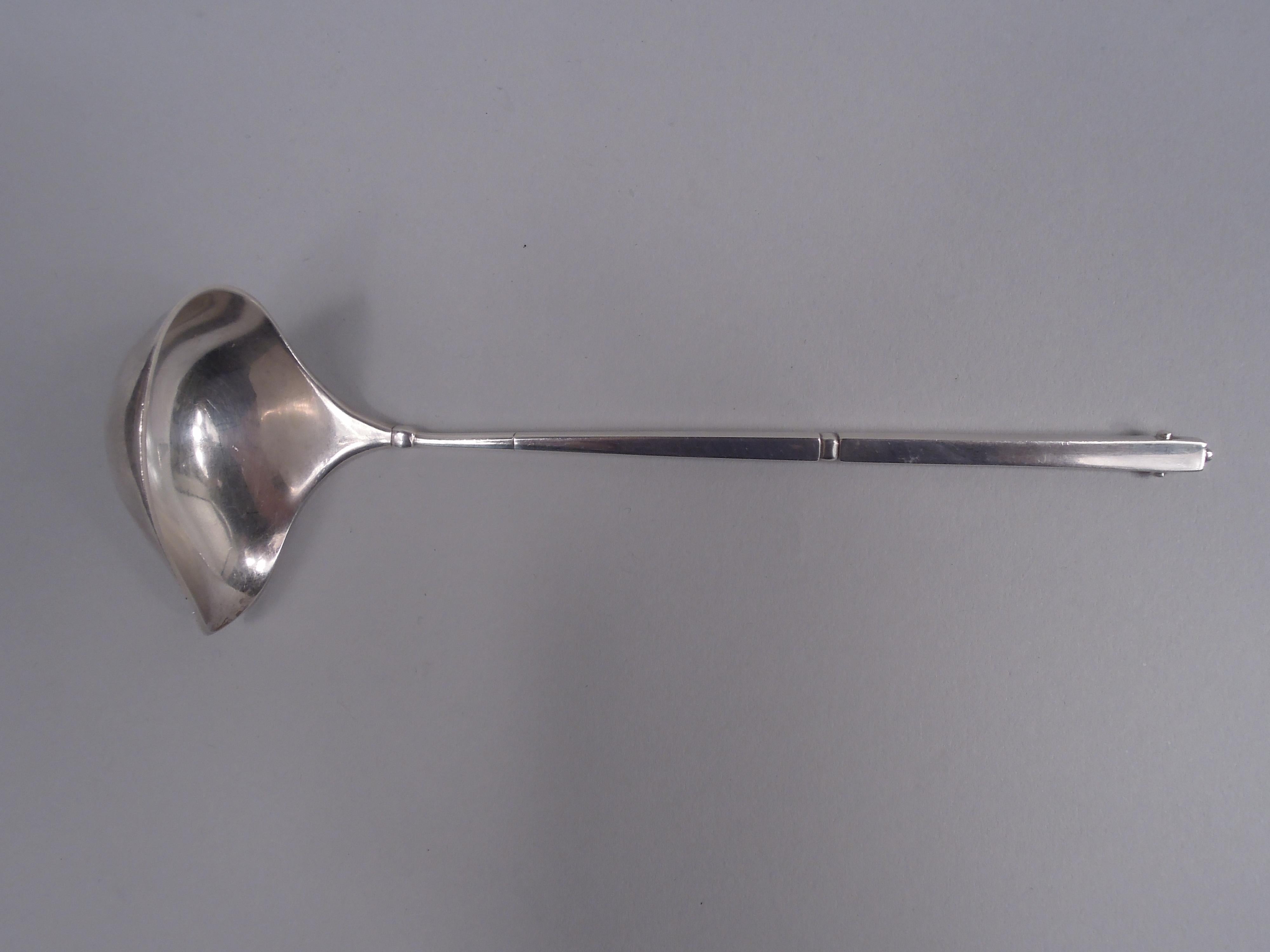 Danish Modern sterling silver sauce ladle in rare ornamental pattern no. 23. Made by Georg Jensen in Copenhagen. Tapering rectilinear handle with mortise and tenon-style side mounts and bead terminal. Narrow ovoid bowl with side spout. Fully marked