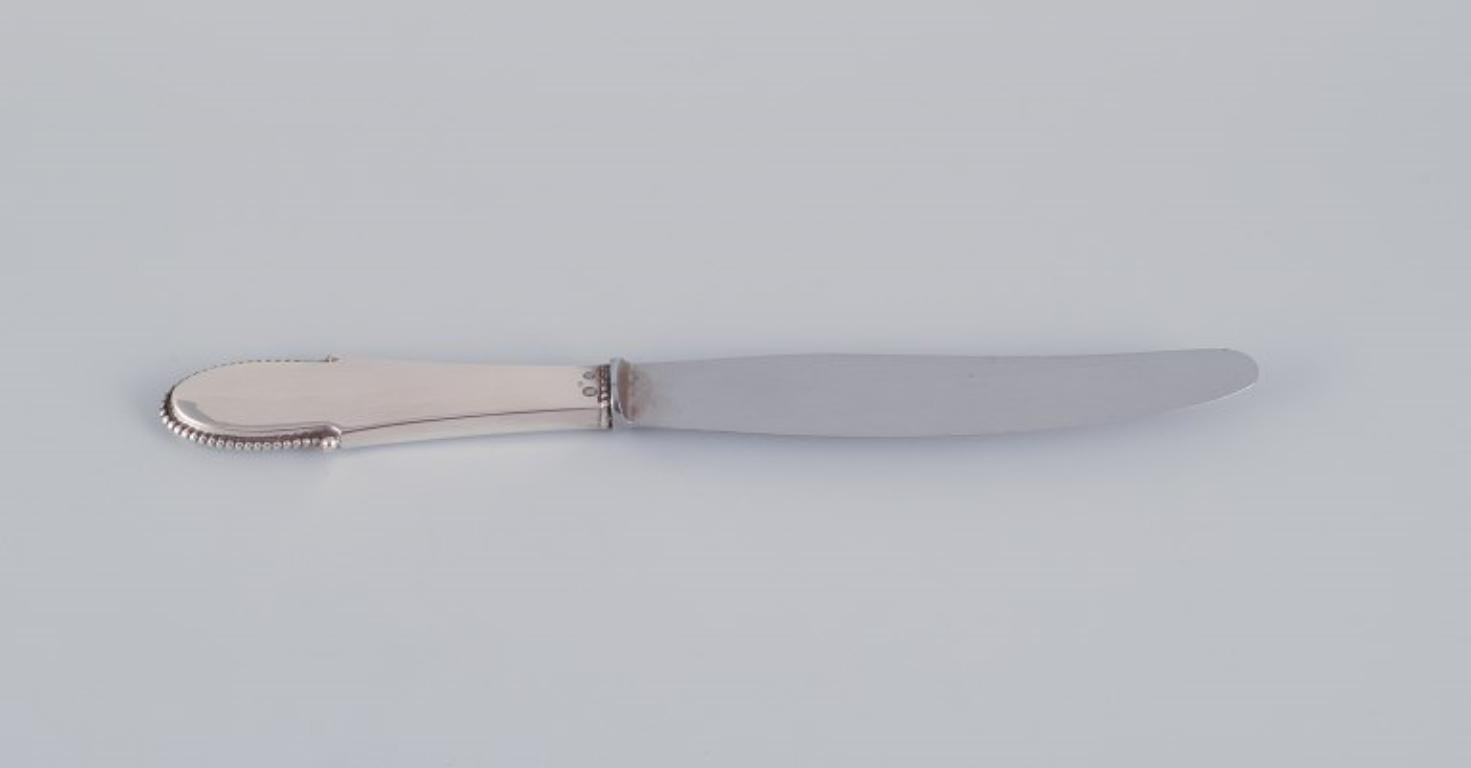 Georg Jensen, a set of four Beaded dinner knives with short handles in 830 silver with stainless steel blades.
Dated 1927 and 1928.
Hallmarked.
Perfect condition.
Dimensions: Length 24.6 cm.
