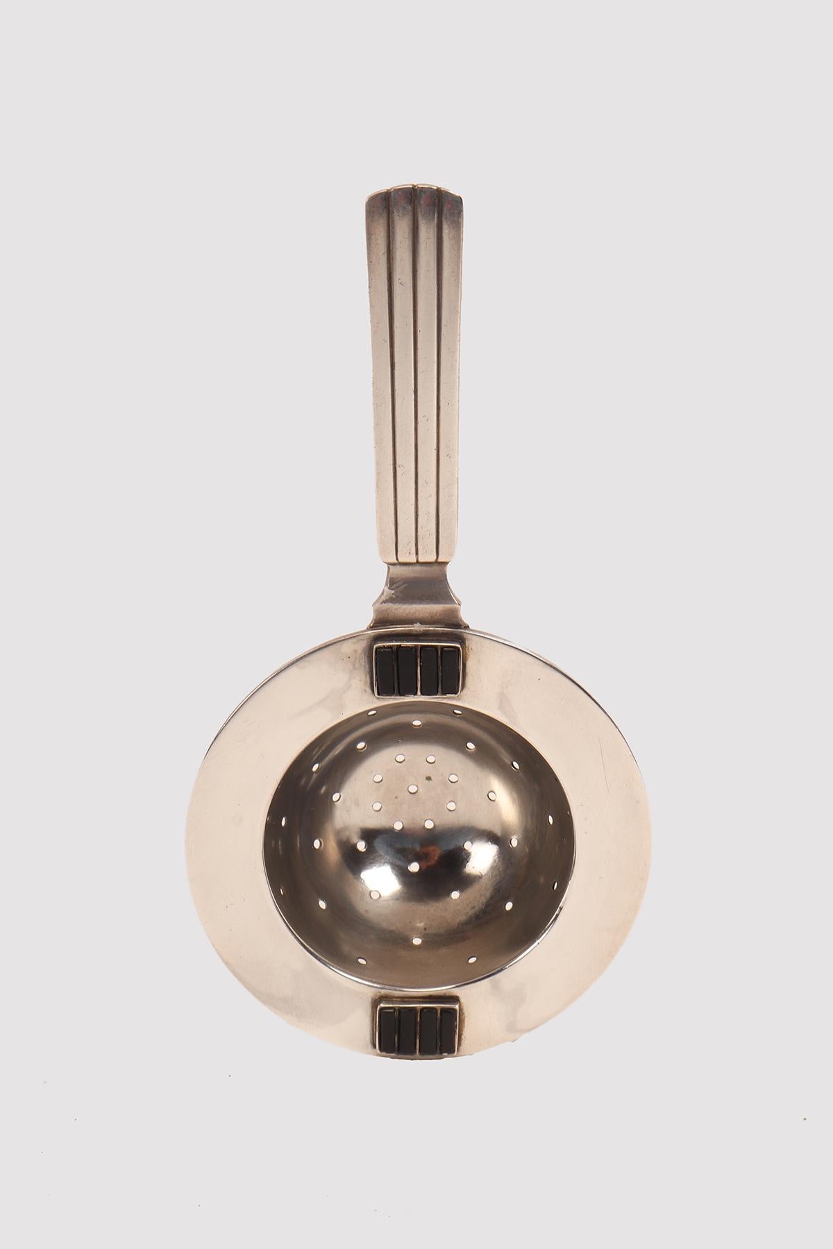 Tea strainer with handle, in silver and black onyx. Designer Sigvaard Bernadotte for Georg Jensen. Copenhagen, Denmark circa 1930.