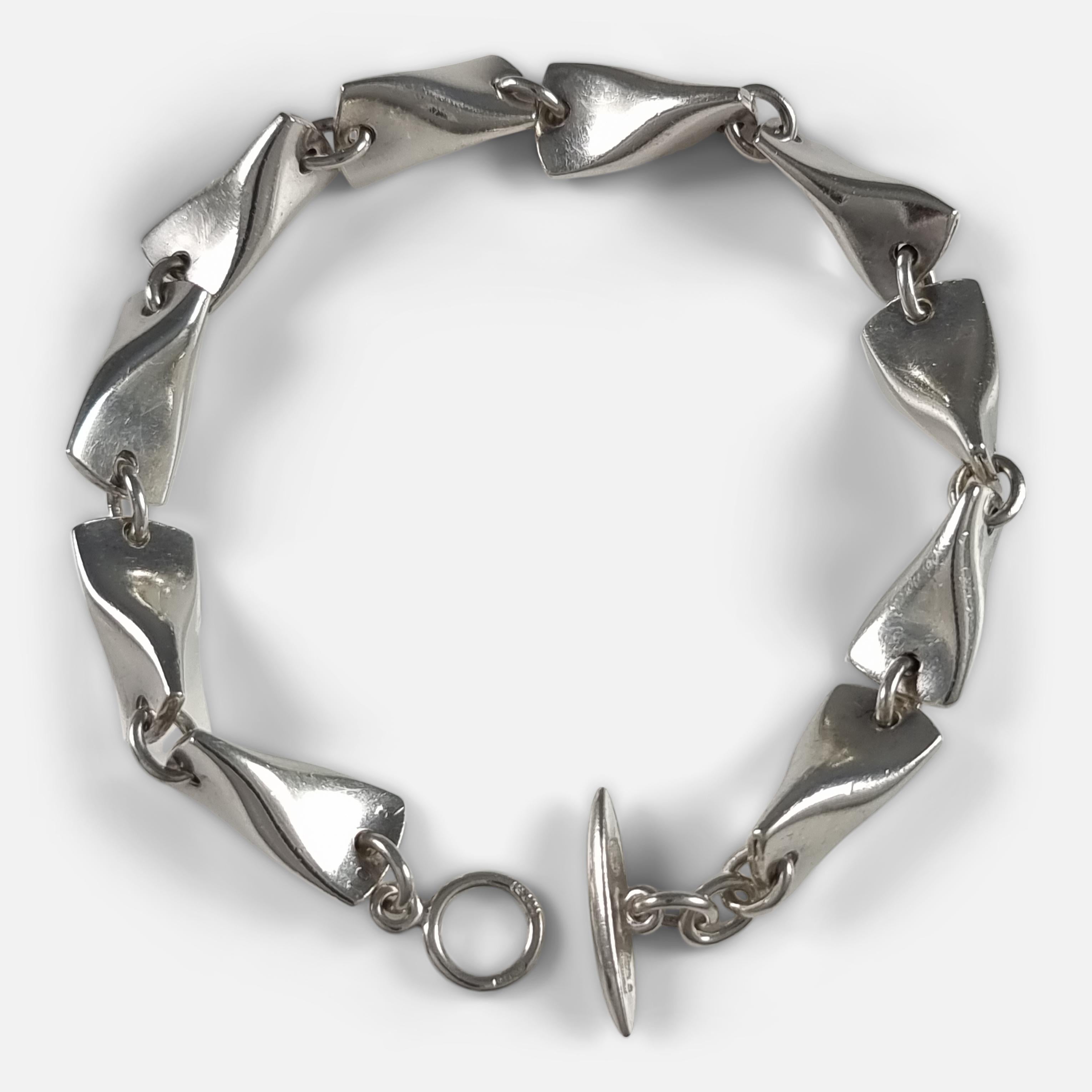 A sterling silver 'Butterfly' Bracelet #104A, designed by Edvard Kindt-Larsen for Georg Jensen.

Stamped with post-1945 Georg Jensen marks, '925S Denmark', '104A', and with London hallmarks for 2000.

Period: - Early 21st century.

Engraving: -