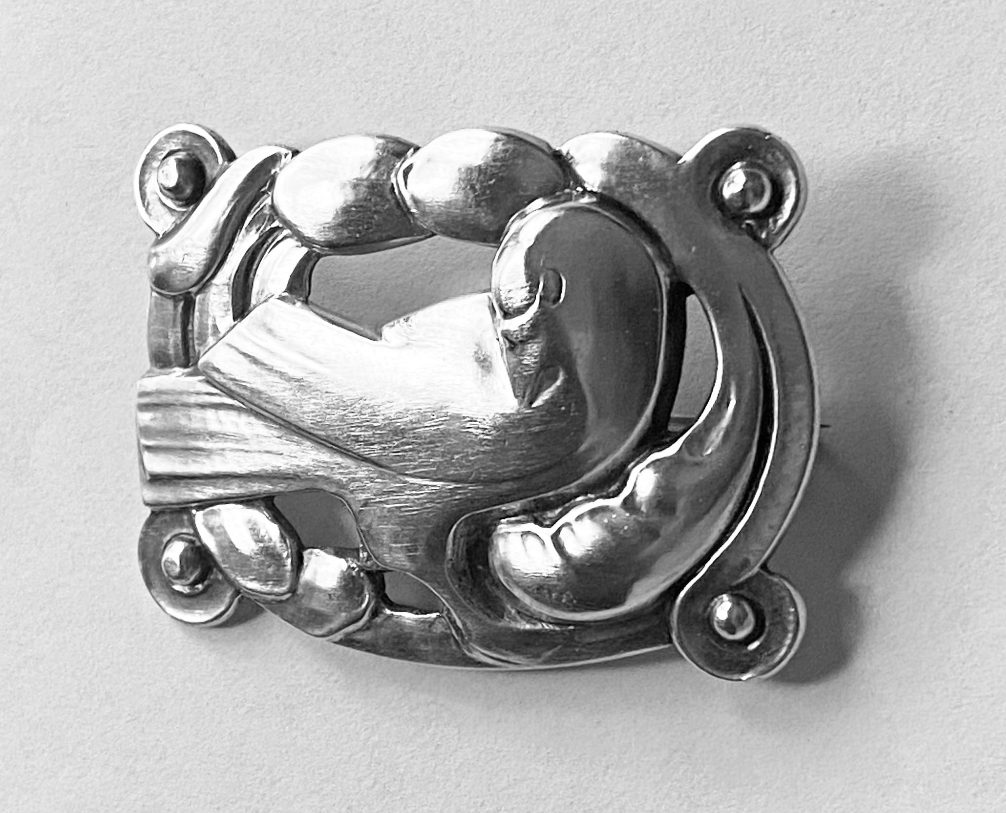 Early Georg Jensen silver dove Brooch Denmark C.1925. The bird set in a rectangular foliate frame with silver beads at each corner, Jensen oval hallmark and 830 and Importe de Danmark 209. Measures: 1.75 x 1 .25 inches. Weight: 11.36 grams. The dove