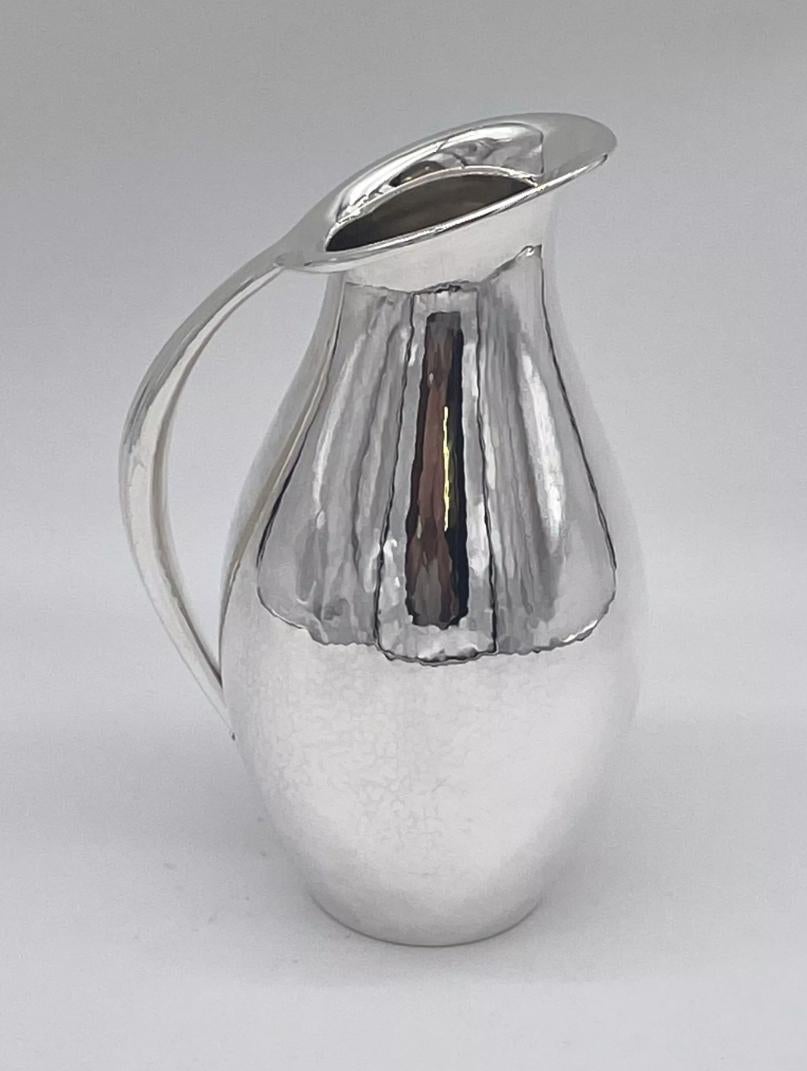 A stylish sterling silver jug/pitcher made by the Danish firm of Georg Jensen and designed by one of the giants of the firm, Johan Rohde.