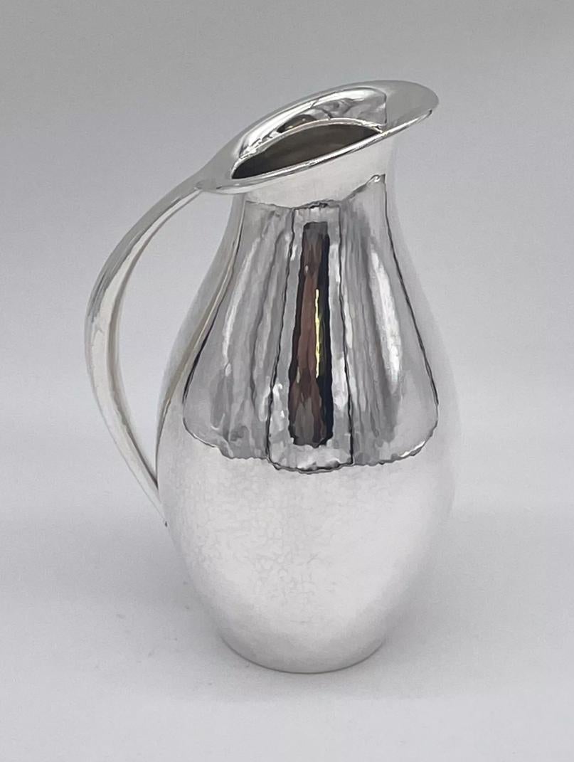 Un élégant pichet en argent sterling fabriqué par la firme danoise Georg Jensen et conçu par l'un des géants de la firme, Johan Rohde.