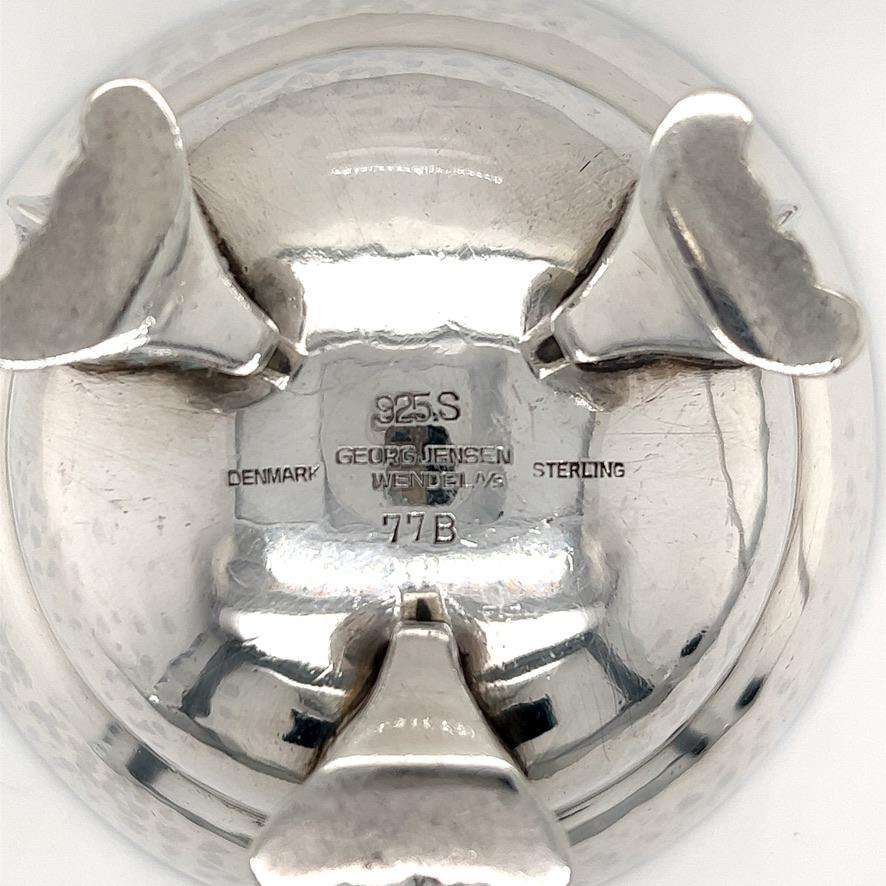 Georg Jensen sterling silver footed salt cellar #77B. Heavy gauge sterling silver with high polish interior and hand stippled exterior. Applied footed base, with hand engraved detail work. Approximately 2 3/4