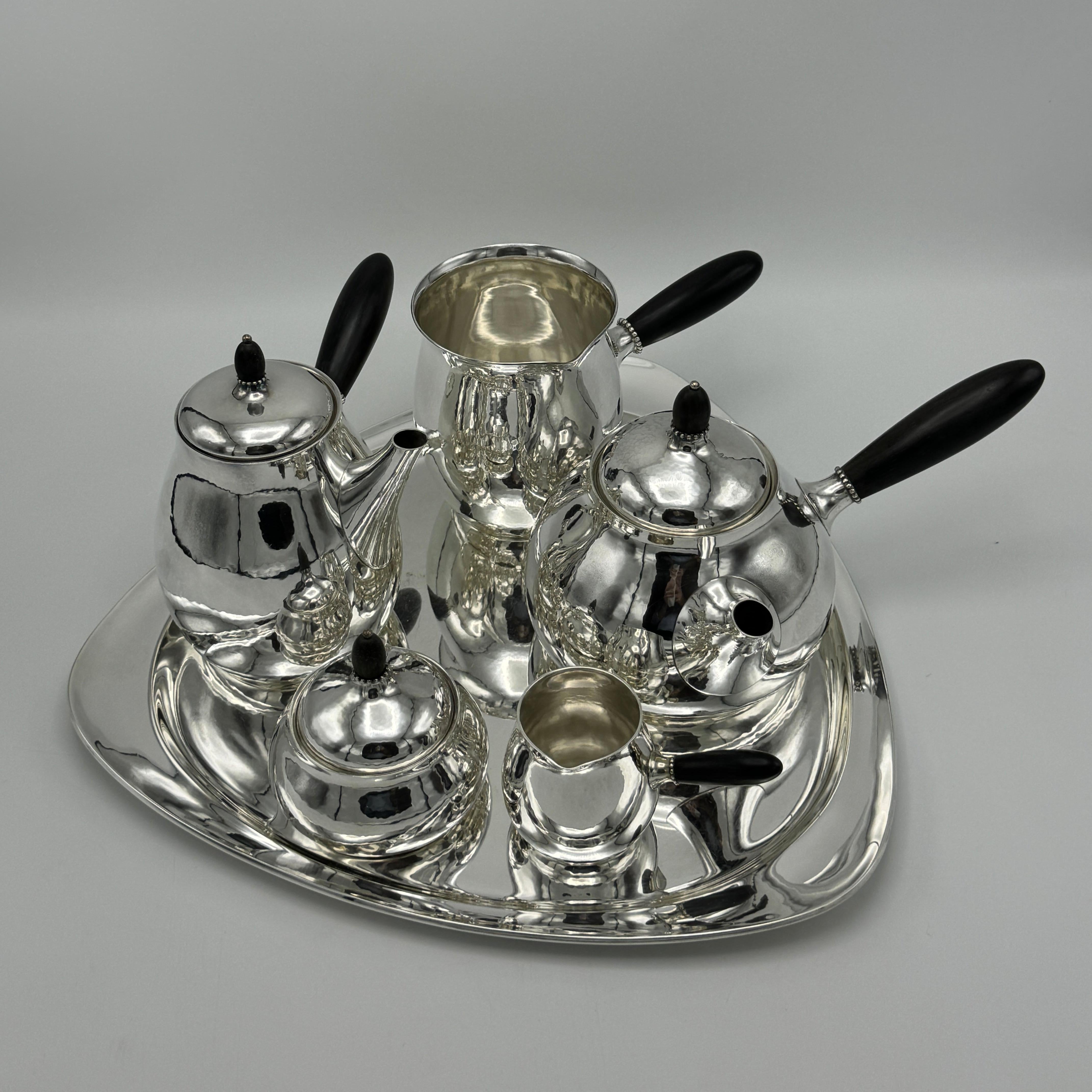 A Georg Jensen designed sterling silver tea and coffee service from Copenhagen, Denmark 1915. All six pieces are hallmarked Sterling Silver and three pieces are fitted with Ebony handles. Marked Sterling, Denmark, with Georg Jensen