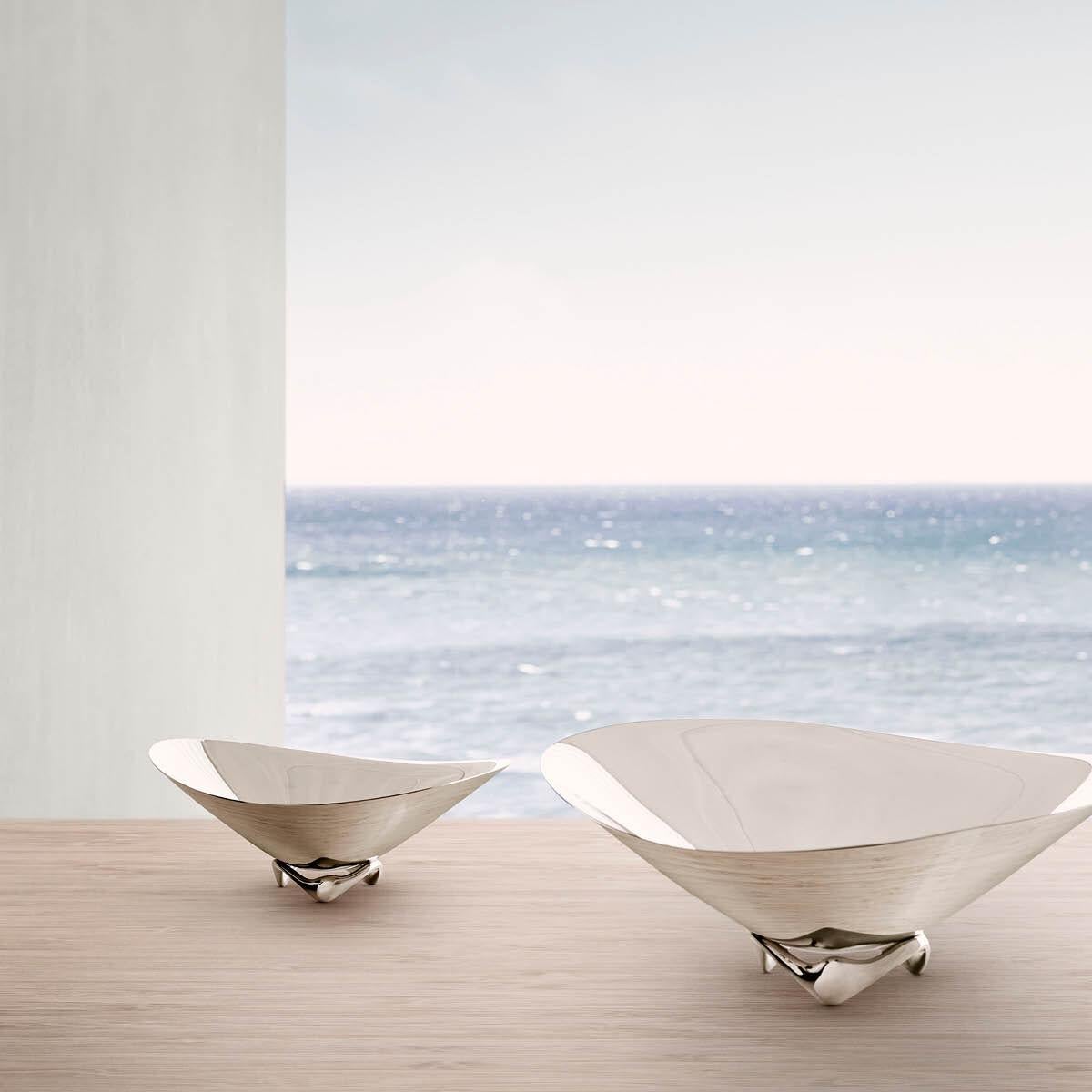 Vividly capturing the movement of the sea, this small decorative bowl makes a striking centrepiece for a table. The fluid, undulating shape seems to almost hover above its stand with the shiny stainless steel surface capturing the light and