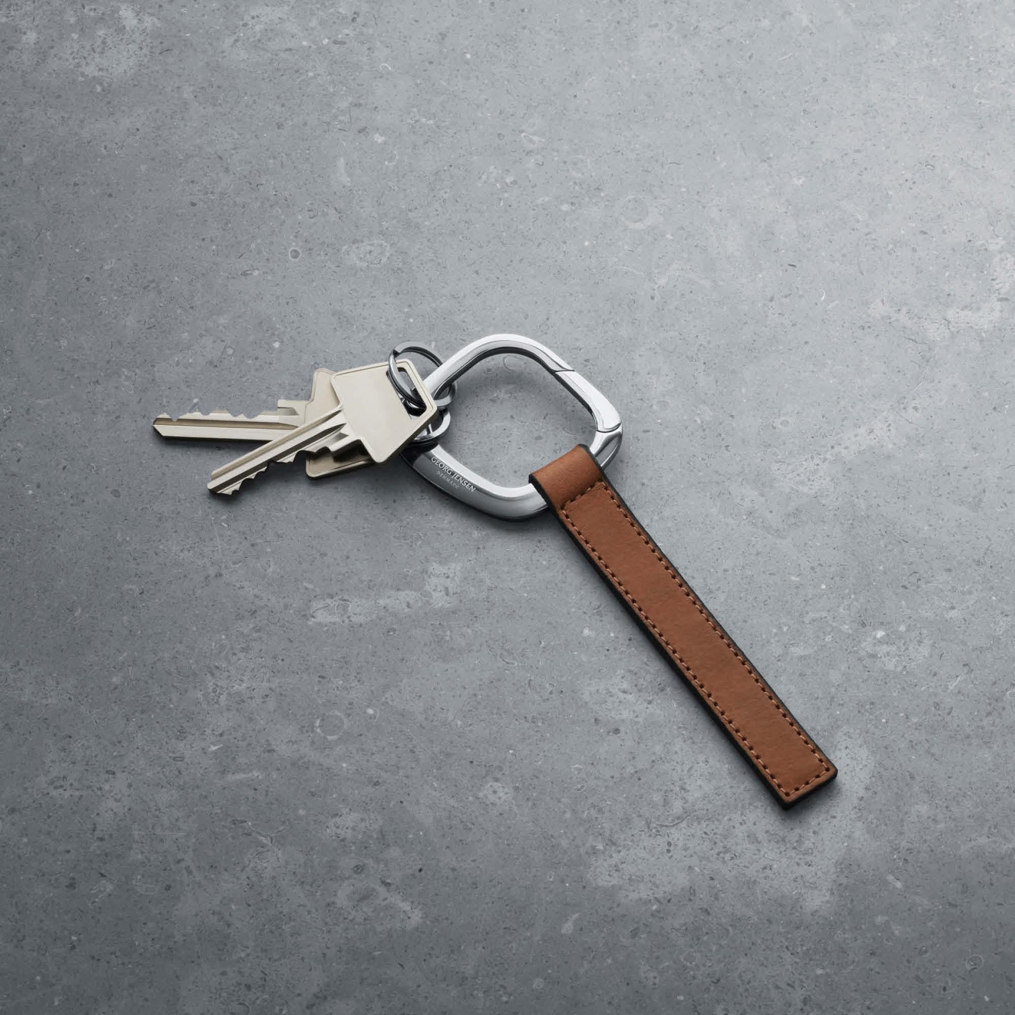Le porte-clés carré est une nouvelle variation d'une forme classique. C'est une forme masculine forte:: mais qui ne manquera pas de gagner sa part d'admiratrices. Moulée dans un bel acier inoxydable poli miroir:: elle est attachée à un court