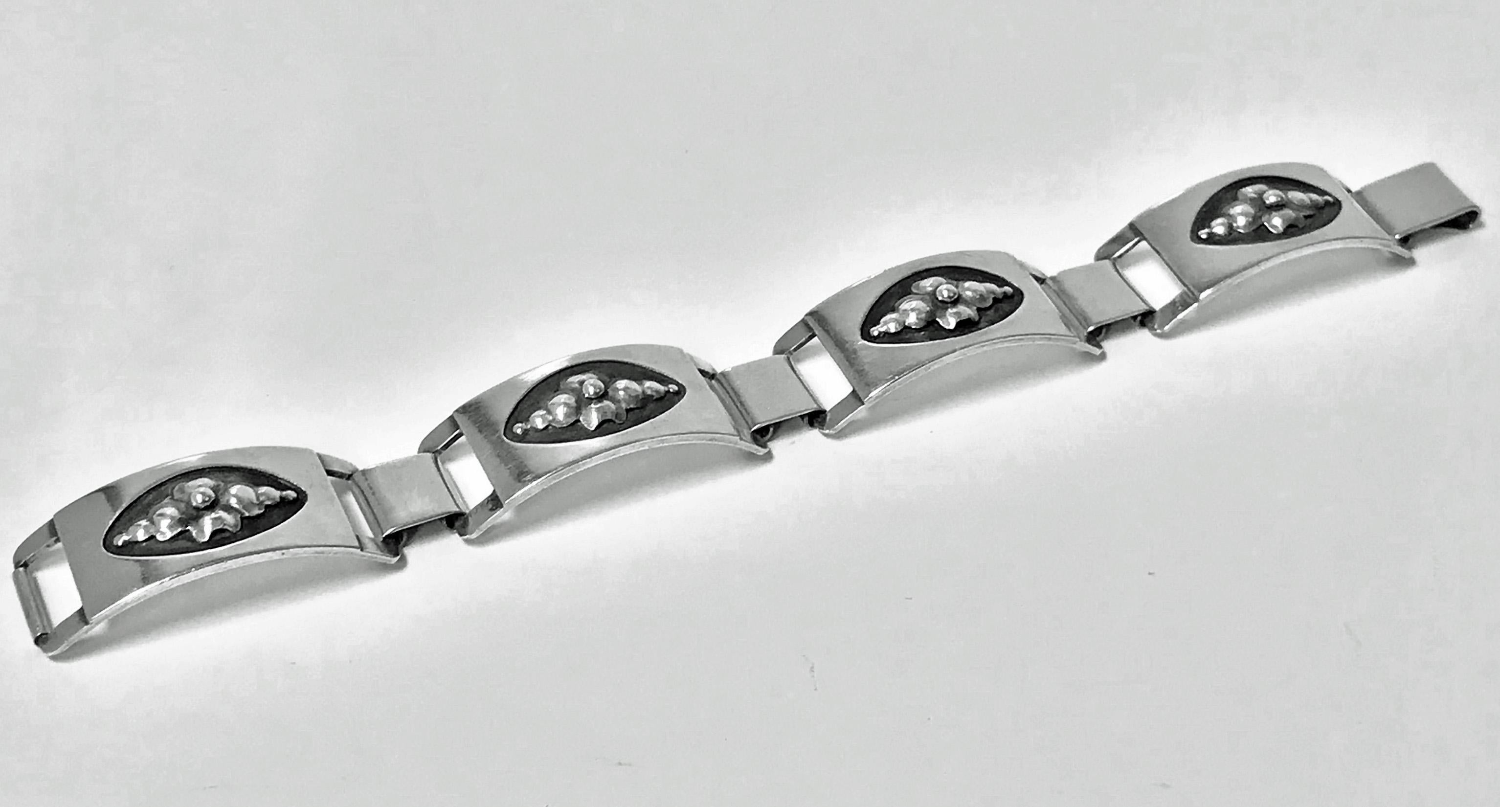 Georg Jensen Sterling Bracelet, C.1944.The design bright flowers applied on an oxidised background, plain polished silver and inter spaced links surround. Georg Jensen Sterling USA marks to reverse and design number 407. Illustrated page 54 Jensen