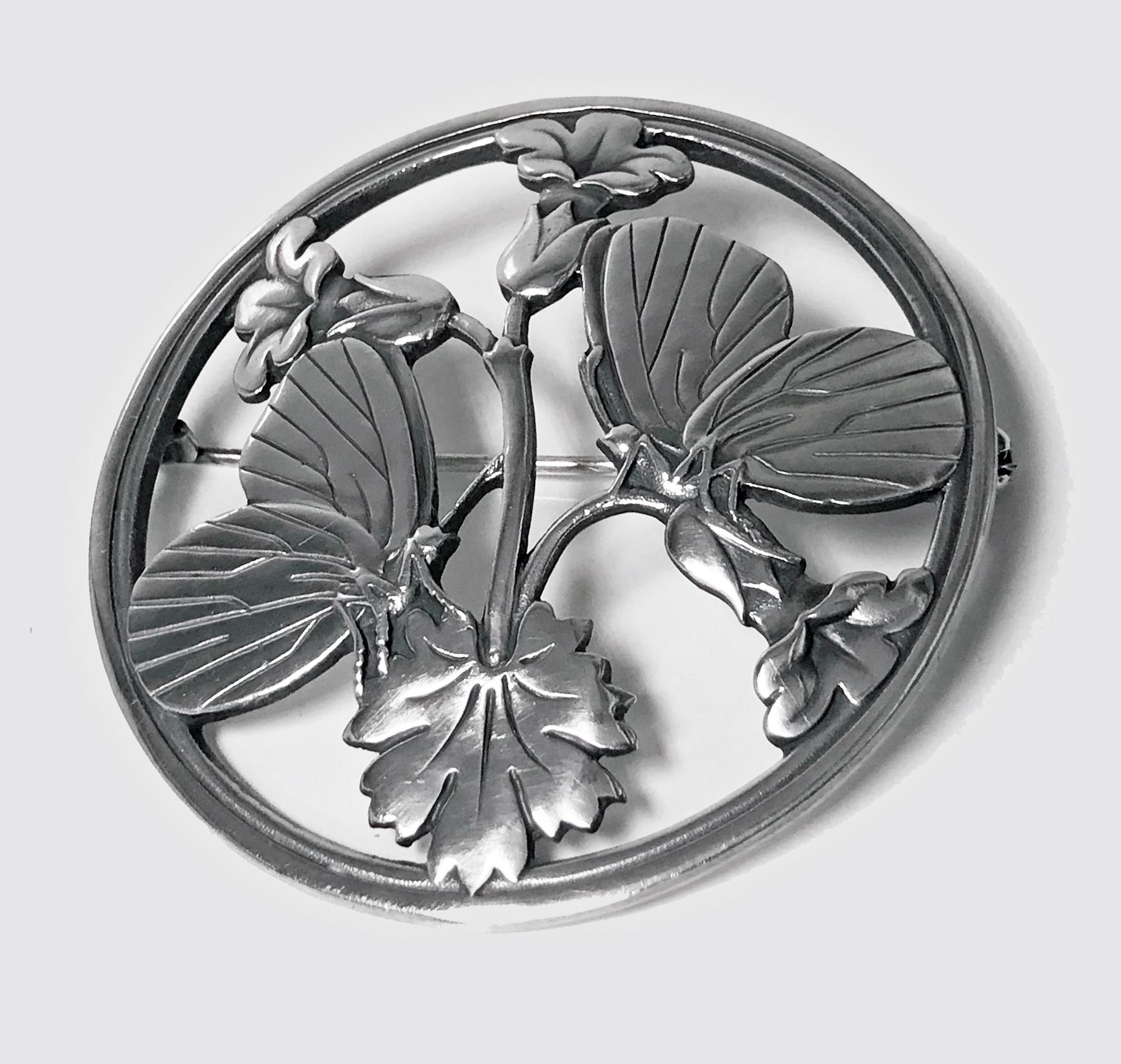 Georg Jensen Sterling Silver Butterfly and stylized Flowers Brooch, 20th century. Fully hallmarked Georg Jensen oval dotted punch, Sterling Denmark and design number 283, C.1950’s. Designed by Arno Malinowski for Georg Jensen. The brooch of circular