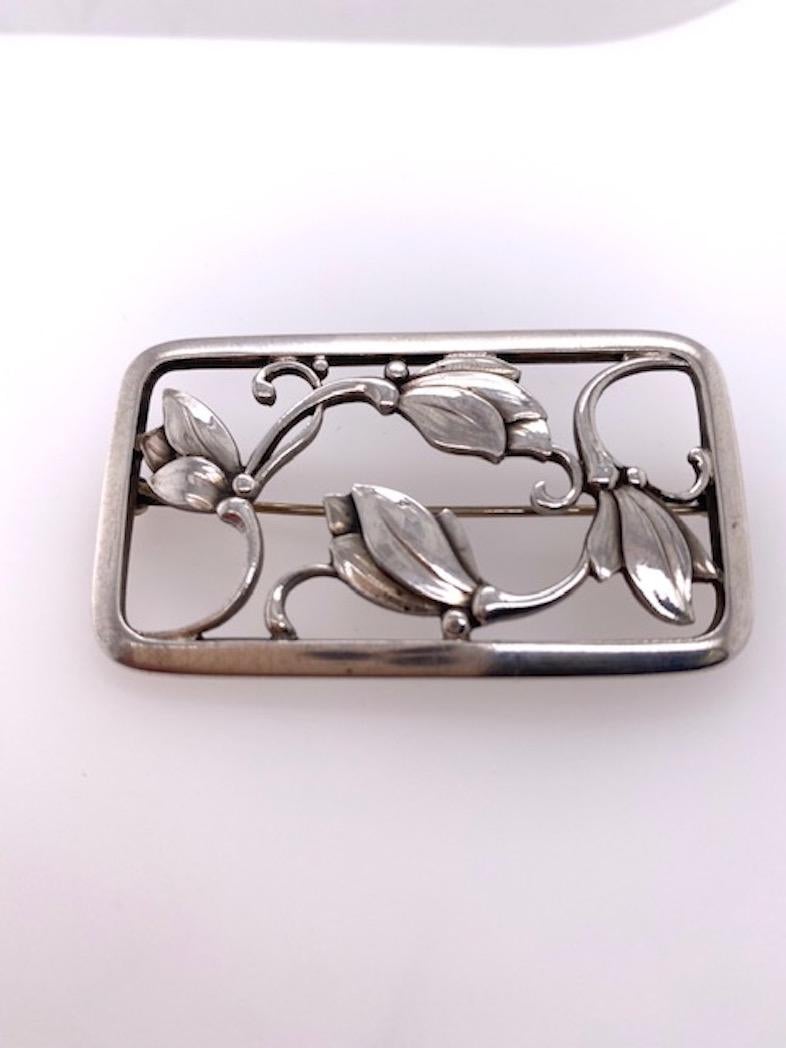 Very attractive sterling silver brooch.  Made, signed and numbered by GEOR JENSEN.  Cut-out leaf pattern, within a solid sterling border.  1