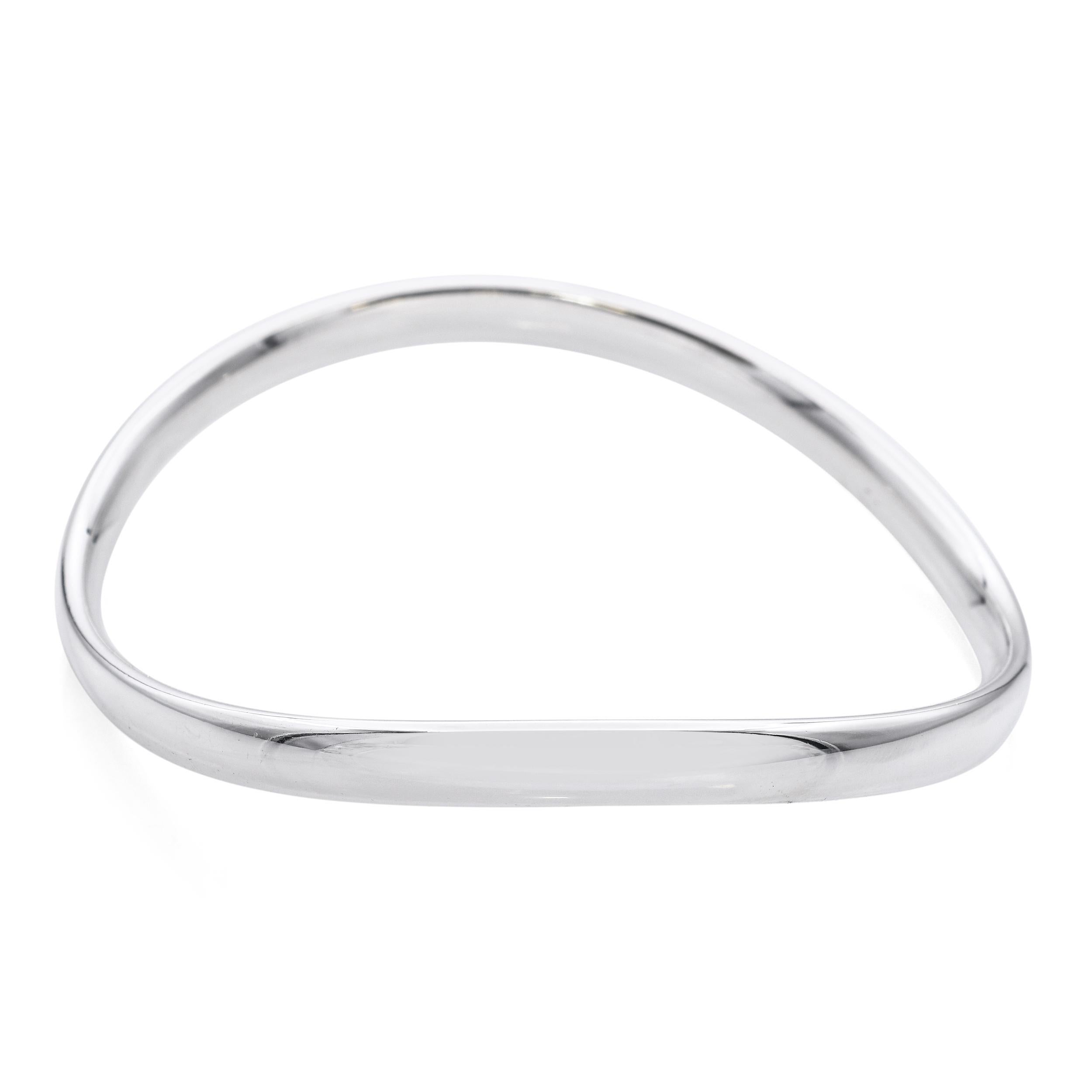 Dieser Armreif aus Sterlingsilber ist ein kühnes Statement für modernes skandinavisches Design und wurde von der bekannten dänischen Designerin Astrid Fog für Georg Jensen entworfen. Das Modell 237A zeigt eine abstrakte Wellenform mit klaren,