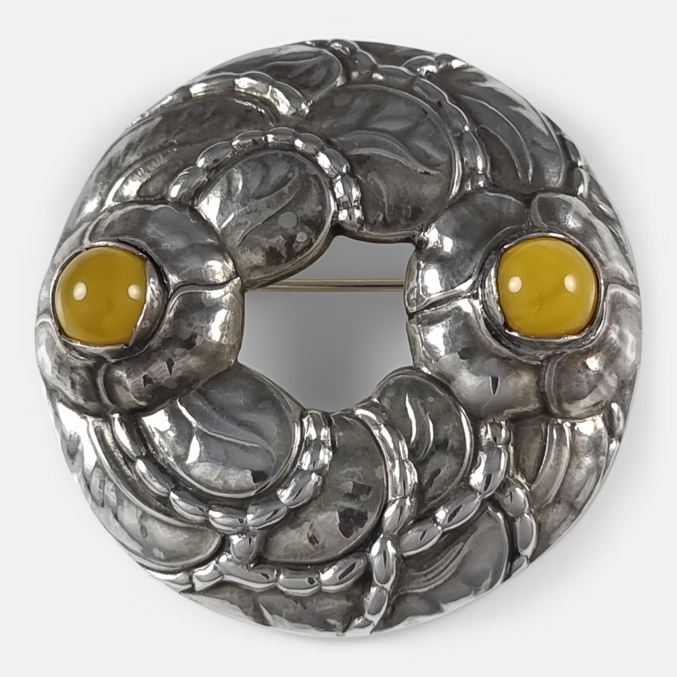 A sterling silver amber anniversary (1904-94) brooch #42, by Georg Jensen.

The brooch is stamped with the Georg Jensen within dotted oval mark, '925 S', 'Denmark', & '42'. Hallmarked with Edinburgh marks.

Period: - Late 20th century.

Date: -