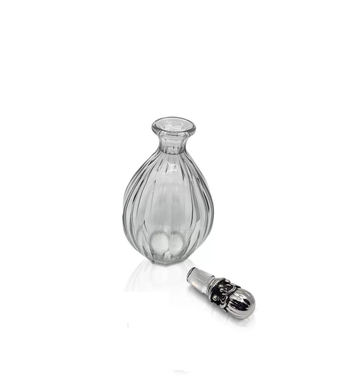 A vintage Georg Jensen sterling silver decanter with ornate stoppers #100 by Georg Jensen and Baccarat crystal decanter. The heavy art nouveau stopper is hand crafted with a great deal of hand chasing involved. The hand hammered stopper with a