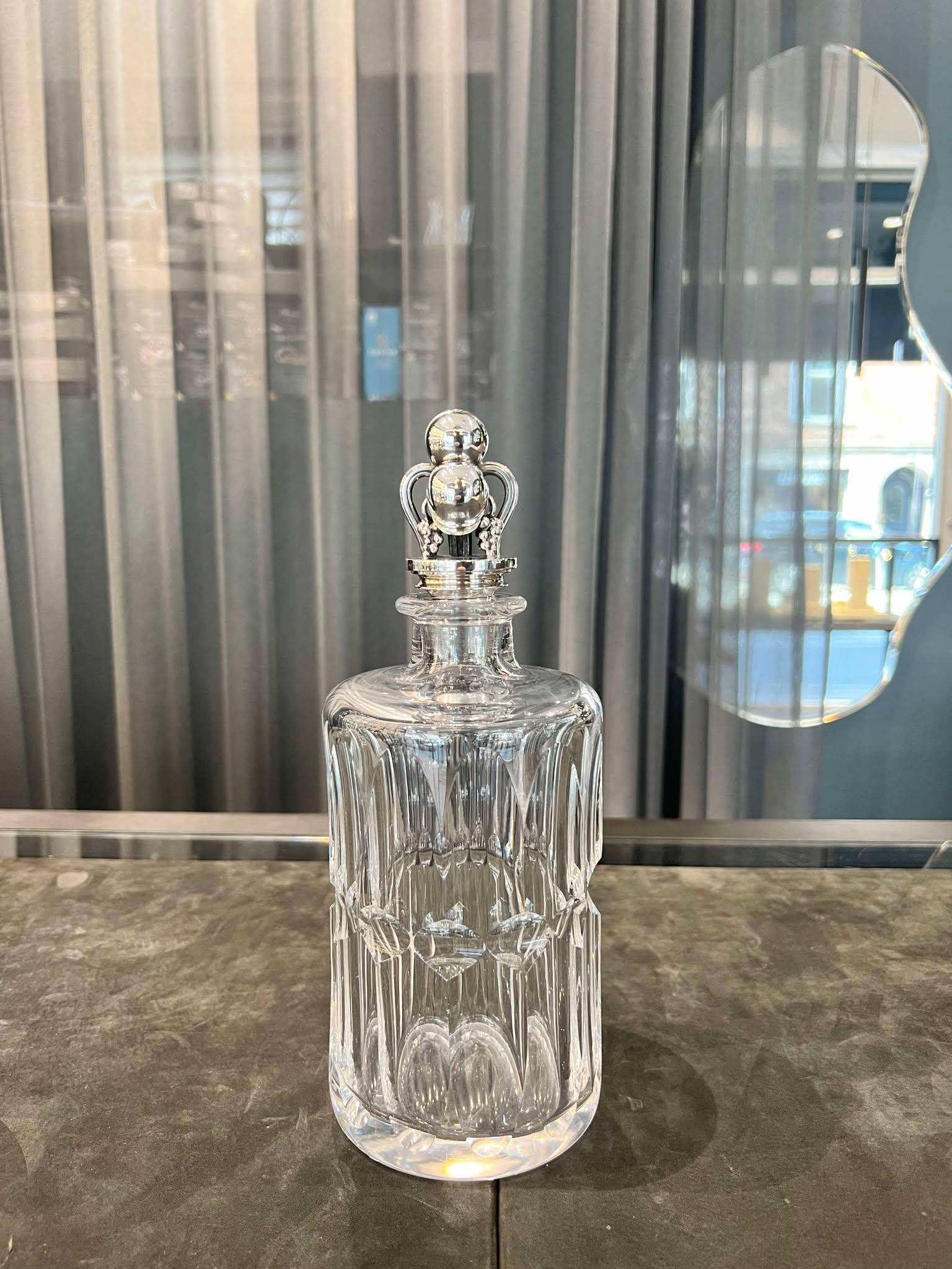 Una garrafa vintage Georg Jensen de plata de ley con tapones ornamentados nº 797 de Harald Nielsen y una garrafa de cristal. El pesado tapón Art Nouveau está hecho a mano con un gran trabajo de persecución manual. El tapón martillado a mano tiene