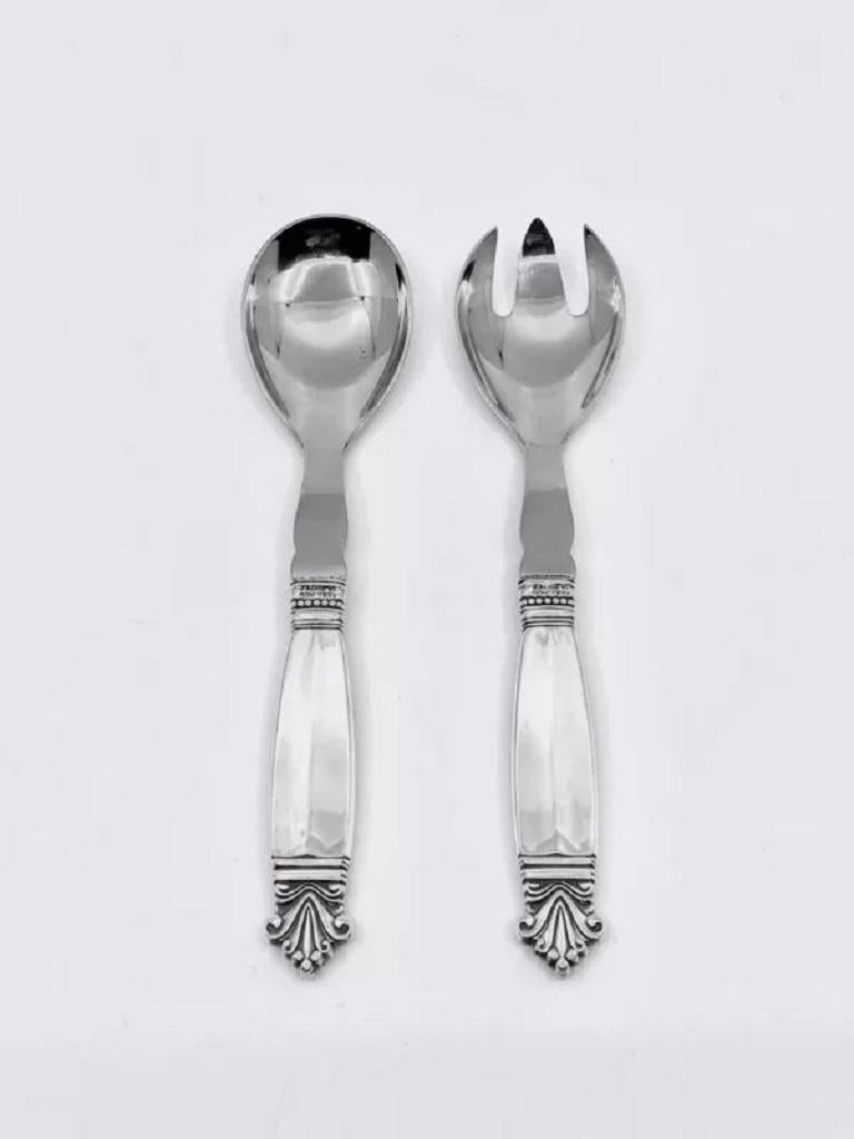 A Georg Jensen sterling silver and stainless steel small salad serving set, set 134 in the Acanthus pattern, design #180 by Johan Rohde from 1917.

Additional information:
Material: Sterling Silver and Stainless Steel
Style: Art Nouveau
Hallmarks: