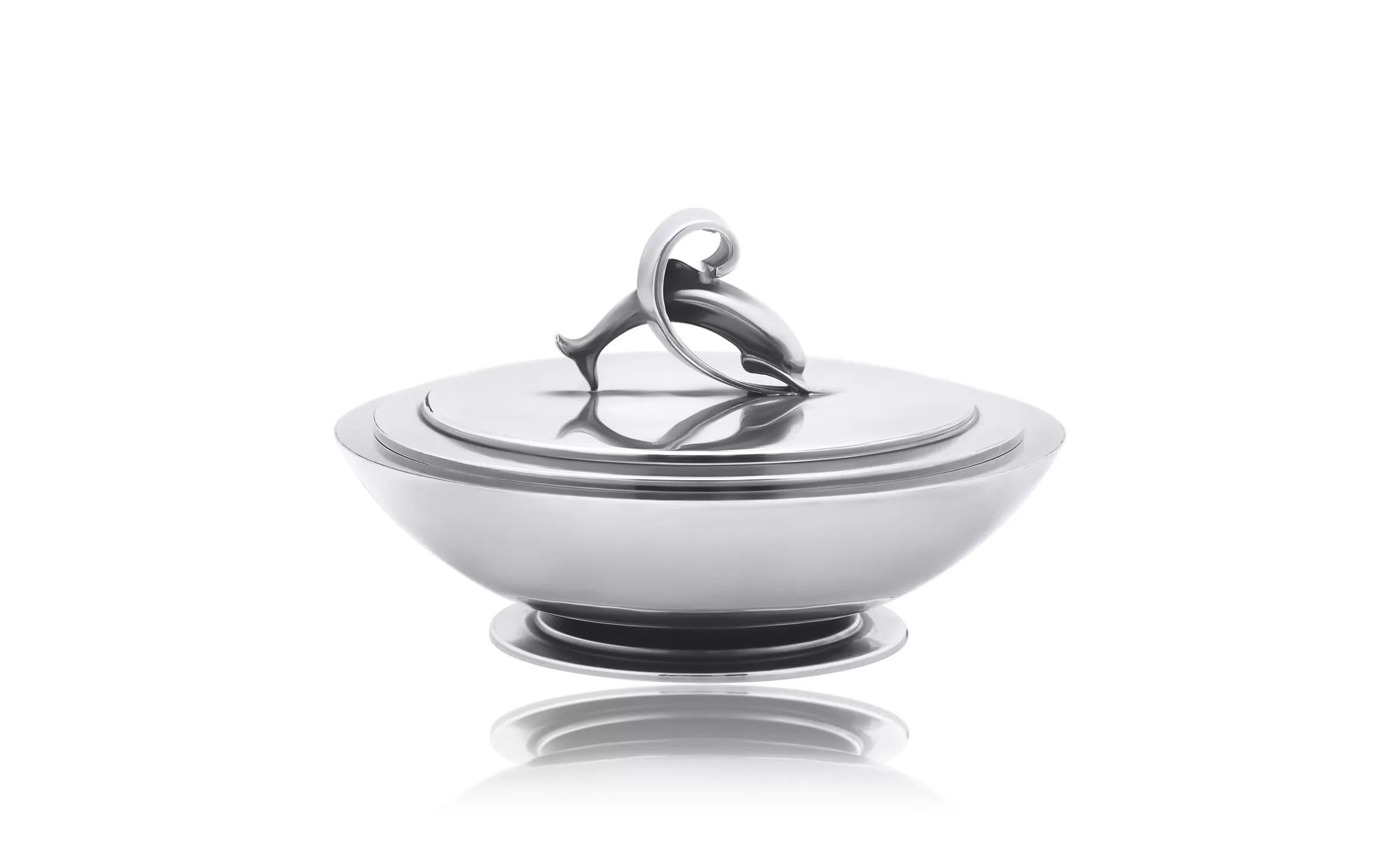 Bombonera Georg Jensen vintage con tapa, diseño nº 150K de Harald Nielsen en 1928.  Base redonda de cuenco elevado con disco circular. La tapa extraíble con diseño de dos discos y objeto delfín.

Dimensiones: Diámetro 5