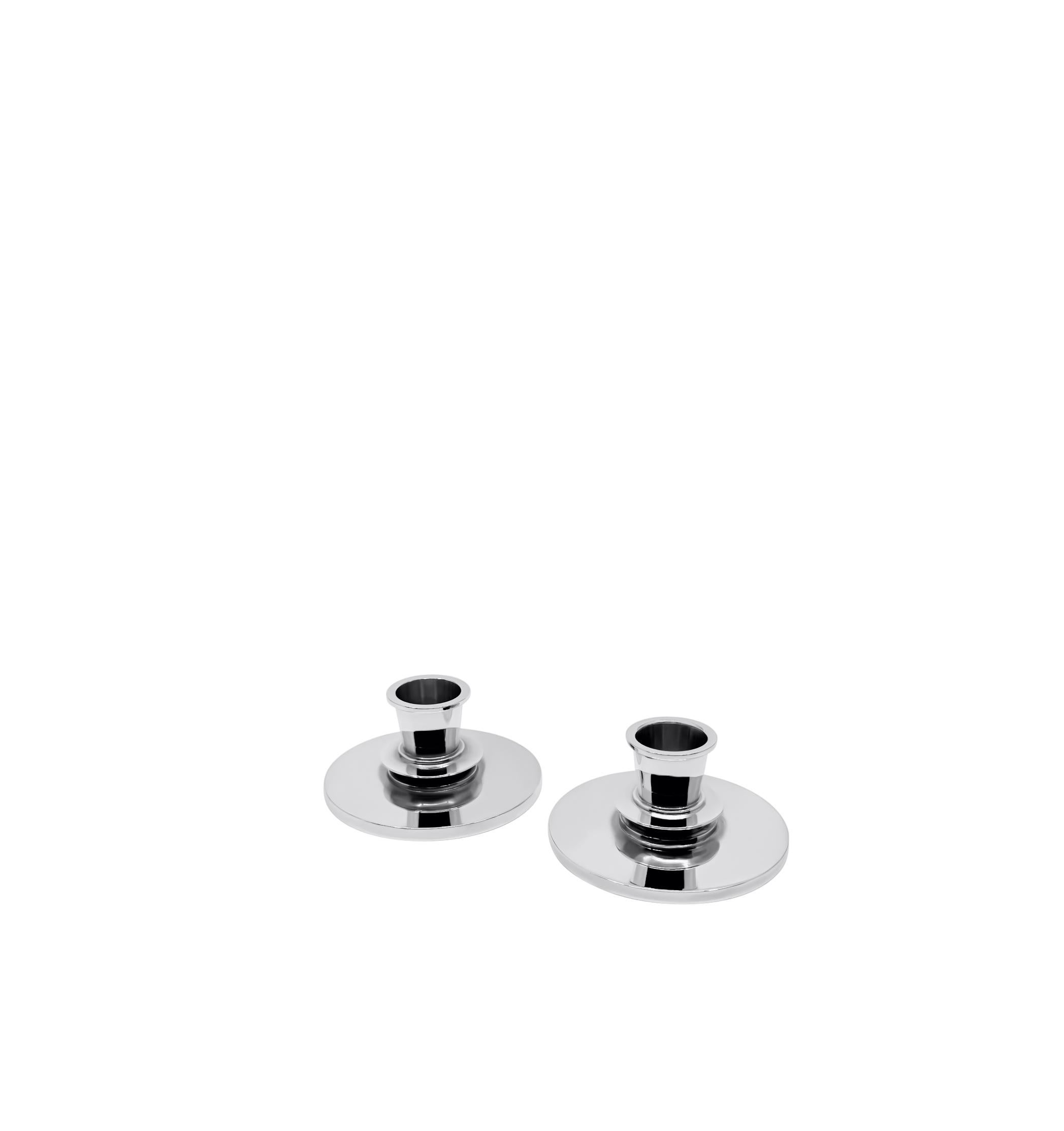 Ein Paar Sterling Silber Georg Jensen Art Deco Kerzenständer, Design #668A von Harald Nielsen aus dem Jahr 1932. Jeweils mit rundem Fuß mit gestufter, oxidierter Mittelscheibe und Leuchte.

Abmessungen:

Maße: jedes Maß ist 2″ (5 cm) hoch, der