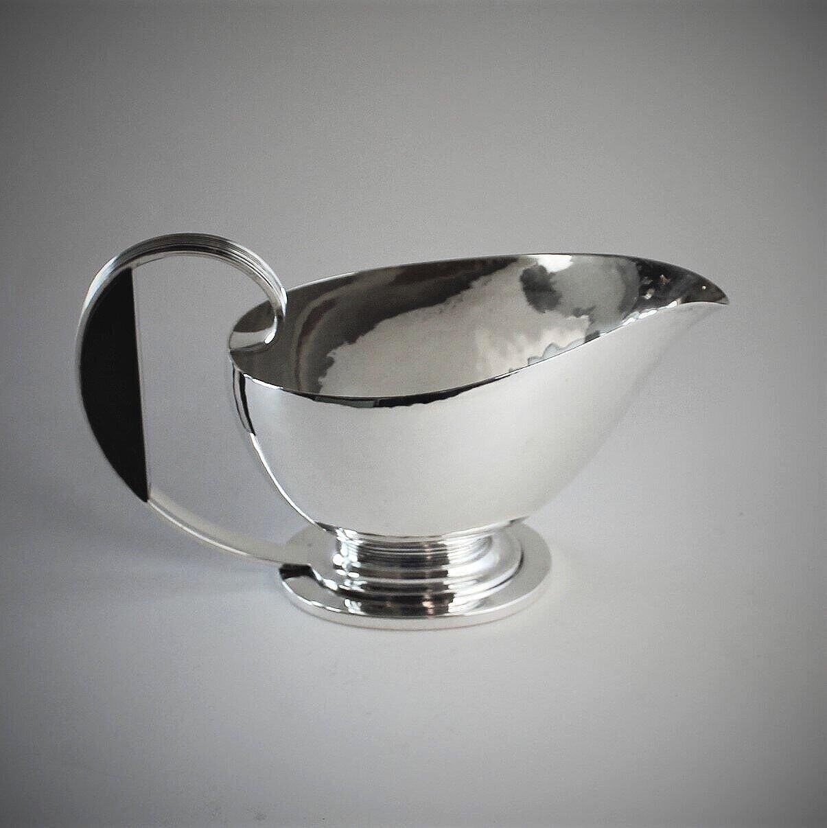 Georg Jensen Sterling silver Art Deco sauce boat with ebony handle, No.766 by Gustav Pedersen.

Heavy and the ebony handle acts as an insulator from the heat. 

Came from an estate of a prominent DC socialite.

A similar example can be seen in